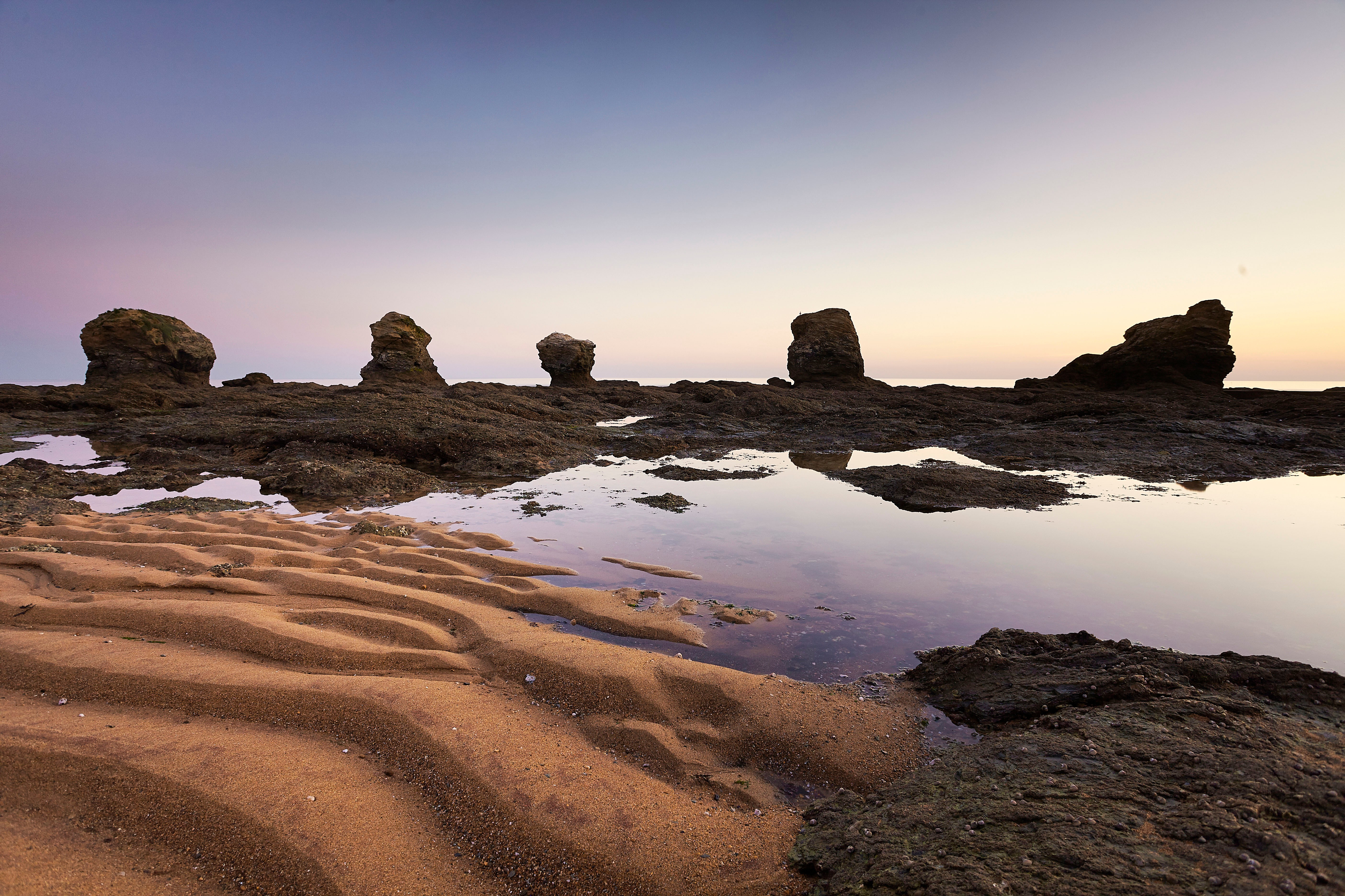 Plage des 5 Pineaux au coucher du soleil avec ses 5 rochers sous un ciel violet