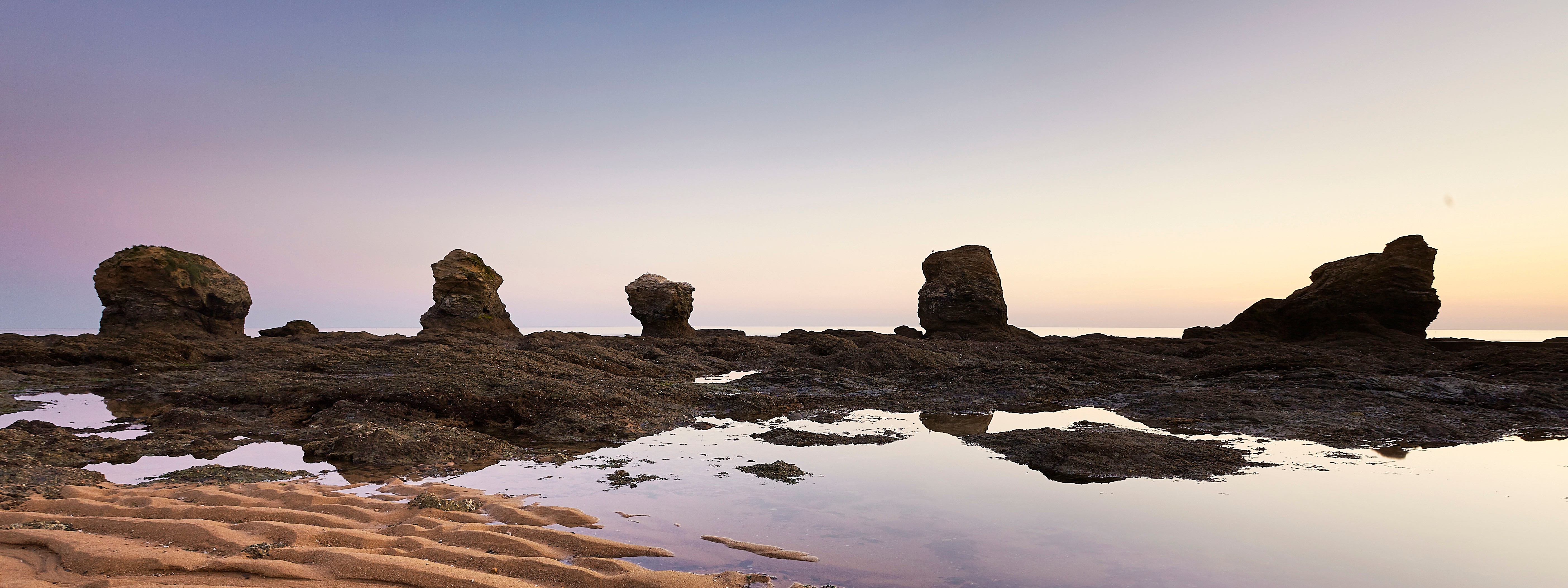 Plage des 5 Pineaux au coucher du soleil avec ses 5 rochers sous un ciel violet
