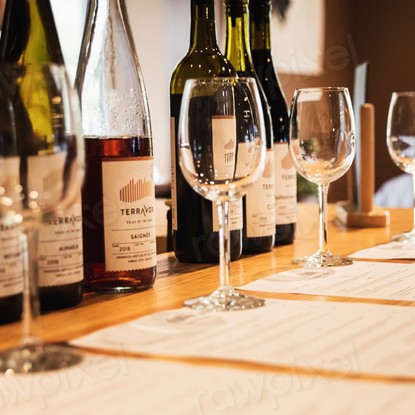 Bouteilles de vin alignées sur un comptoir avec des verres à vin vides