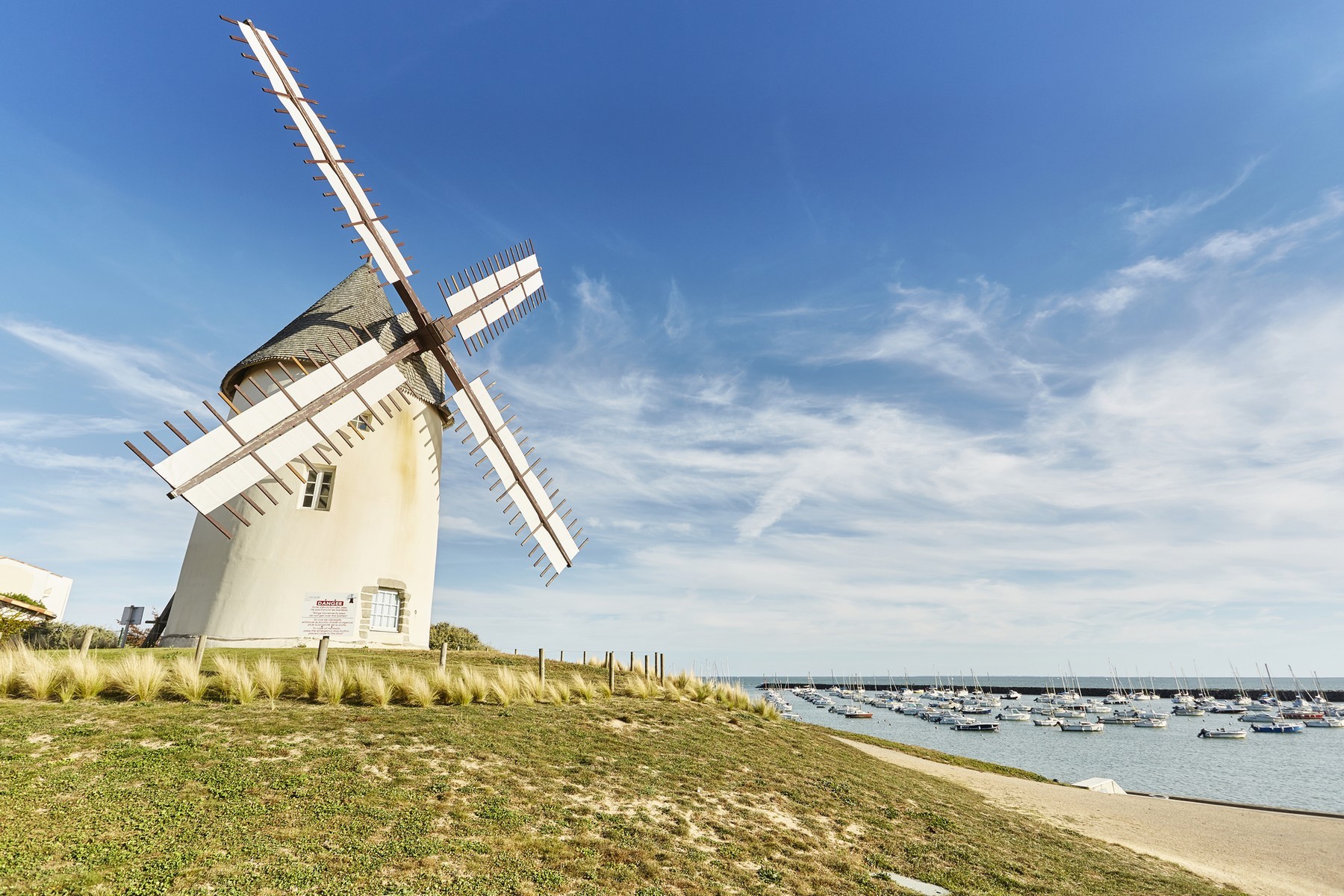Moulin de Jard sur Mer sous un beau ciel bleu à côté du port avec des bateaux amarrés