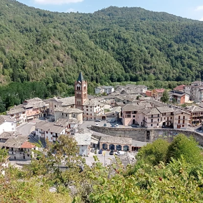 Vue d’en haut sur le la commune de Melle avec des habitations, un clocher et une vaste forêt boisée qui s’étend au fond.