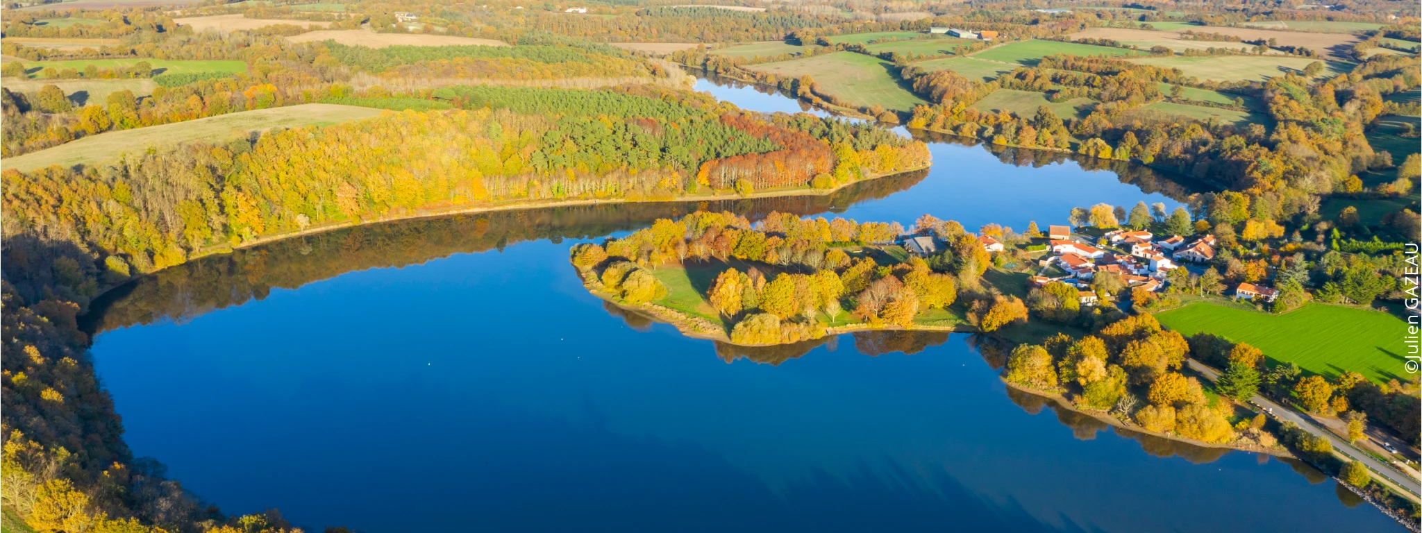 Vue aérienne sur le lac du Jaunay avec quelques habitations et une campagne verdoyante