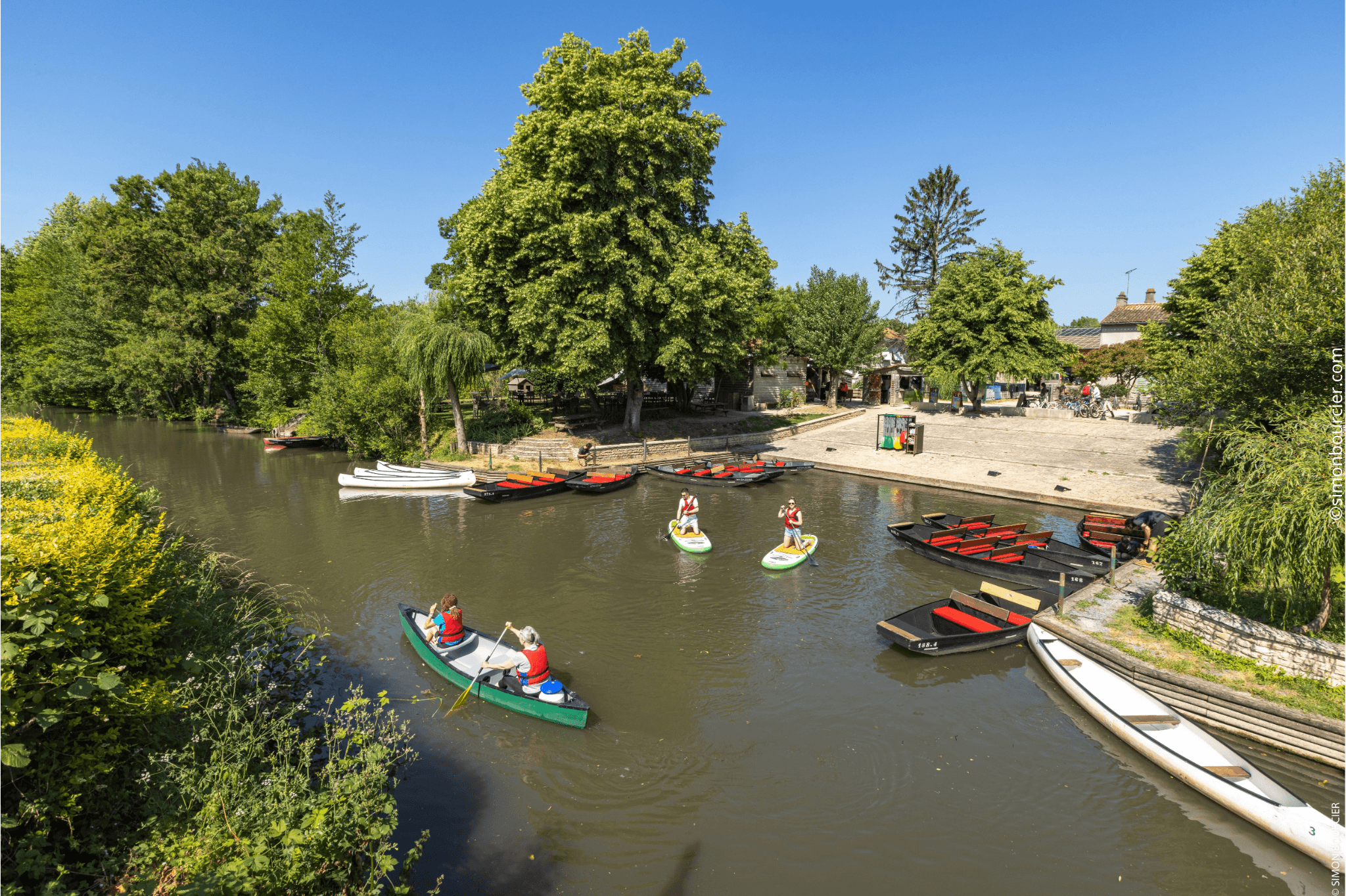 Embarcadère du Mazeau avec des personnes en barque et d’autre en paddle sur le marais