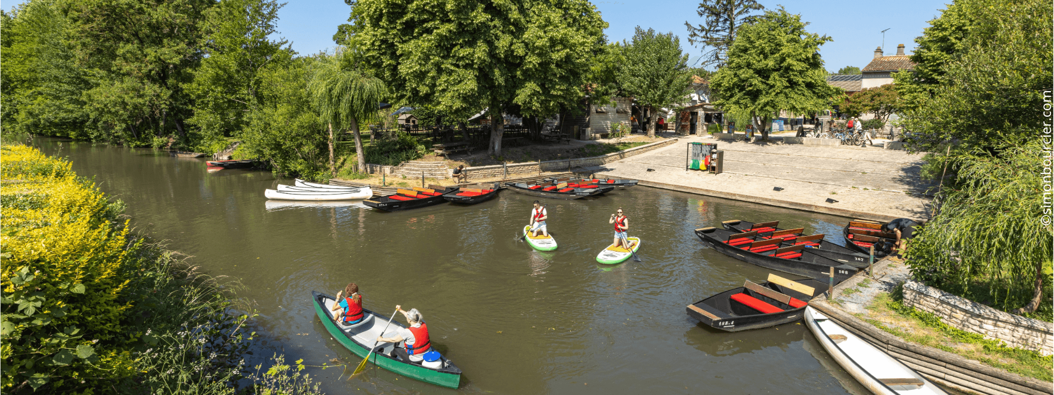 Embarcadère du Mazeau avec des personnes en barque et d’autre en paddle sur le marais