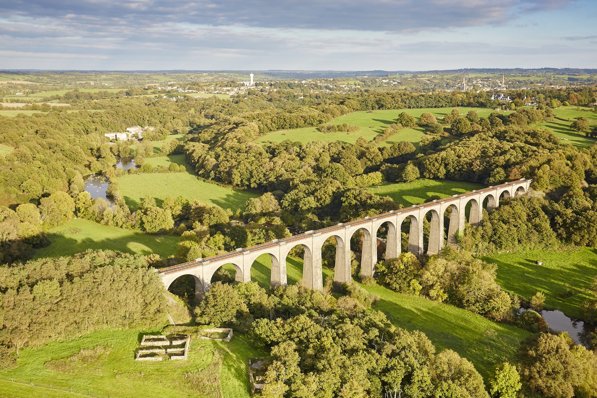 Vue aérienne sur la campagne du bocage avec des champs et arbres verts, surplombée par le Viaduc passant sur la rivière de la Sèvre Nantaise.