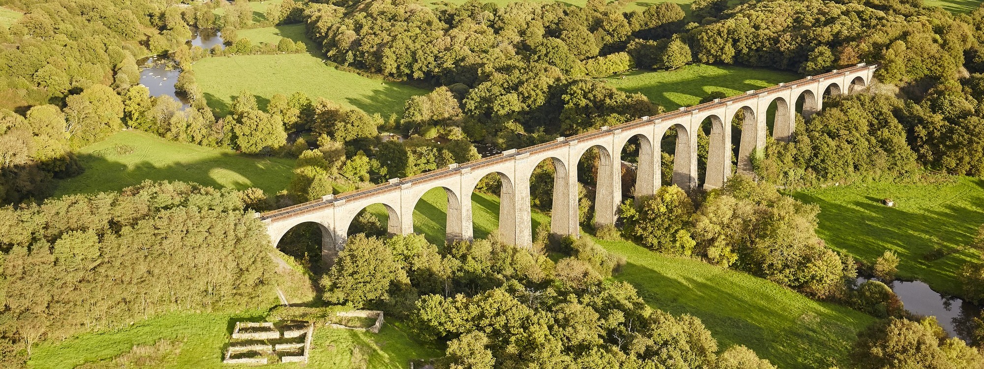 Vue aérienne sur la campagne du bocage avec des champs et arbres verts, surplombée par le Viaduc passant sur la rivière de la Sèvre Nantaise.
