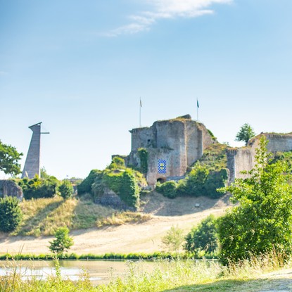 Famille composée d’adultes et enfants parcourant un chemin à vélos devant le célèbre château de Tiffauges
