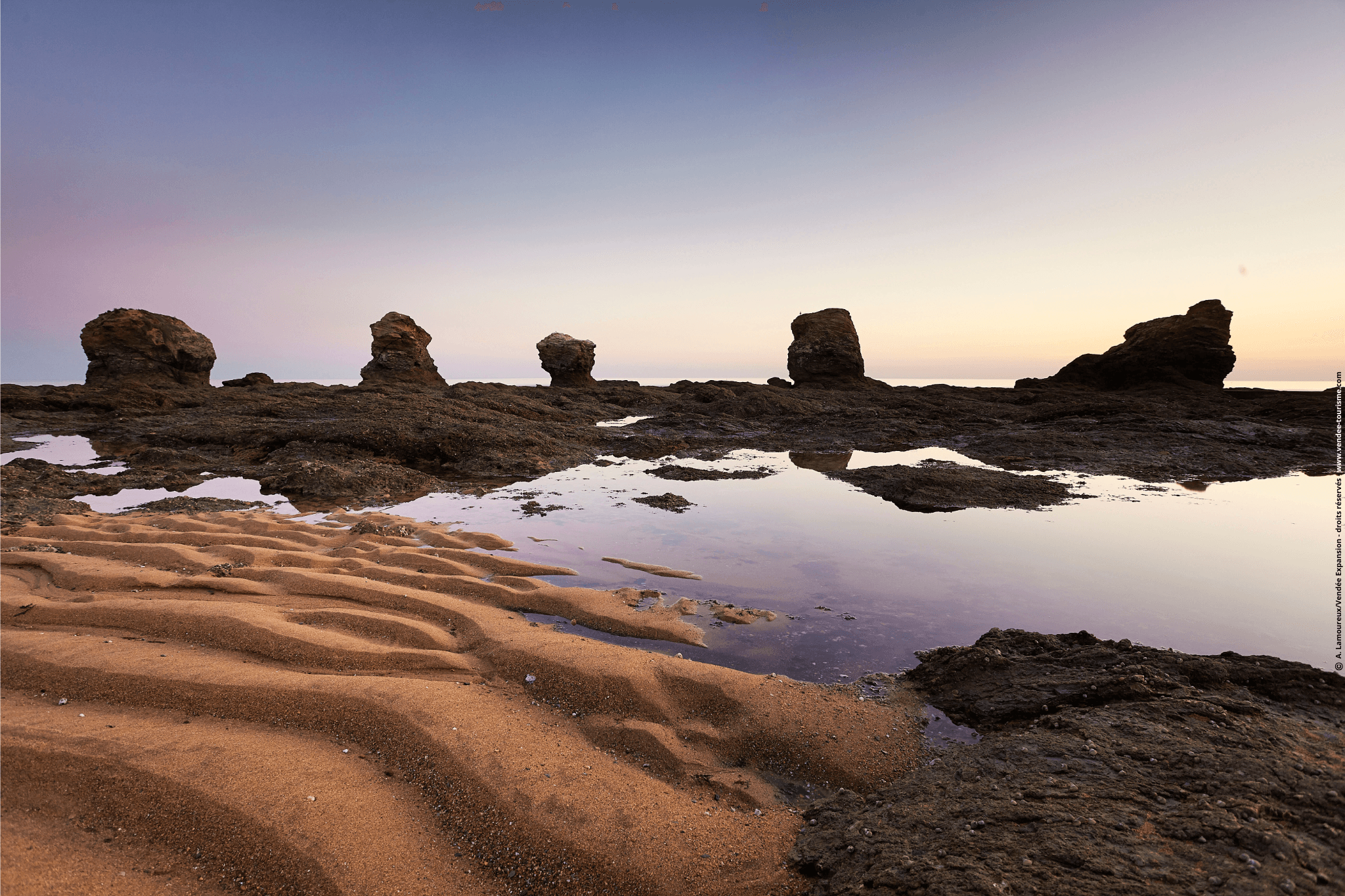 Plage des 5 Pineaux au coucher du soleil avec ses 5 rochers sous un ciel violet