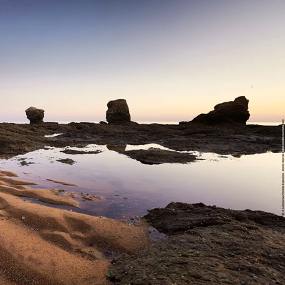 Plage des 5 Pineaux au coucher du soleil avec ses 5 rochers sous un ciel violet