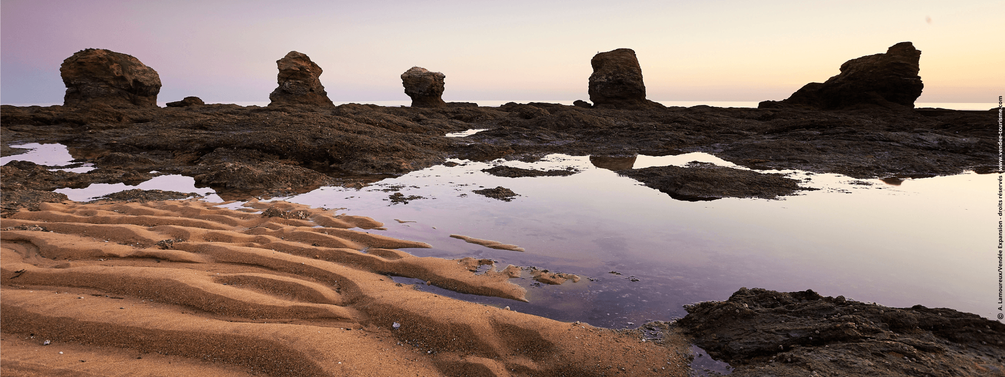 Plage des 5 Pineaux au coucher du soleil avec ses 5 rochers sous un ciel violet