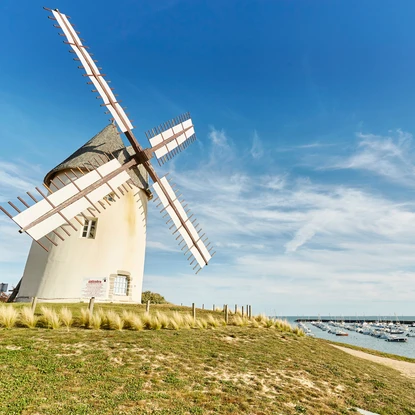 Moulin de Jard sur Mer sous un beau ciel bleu à côté du port avec des bateaux amarrés