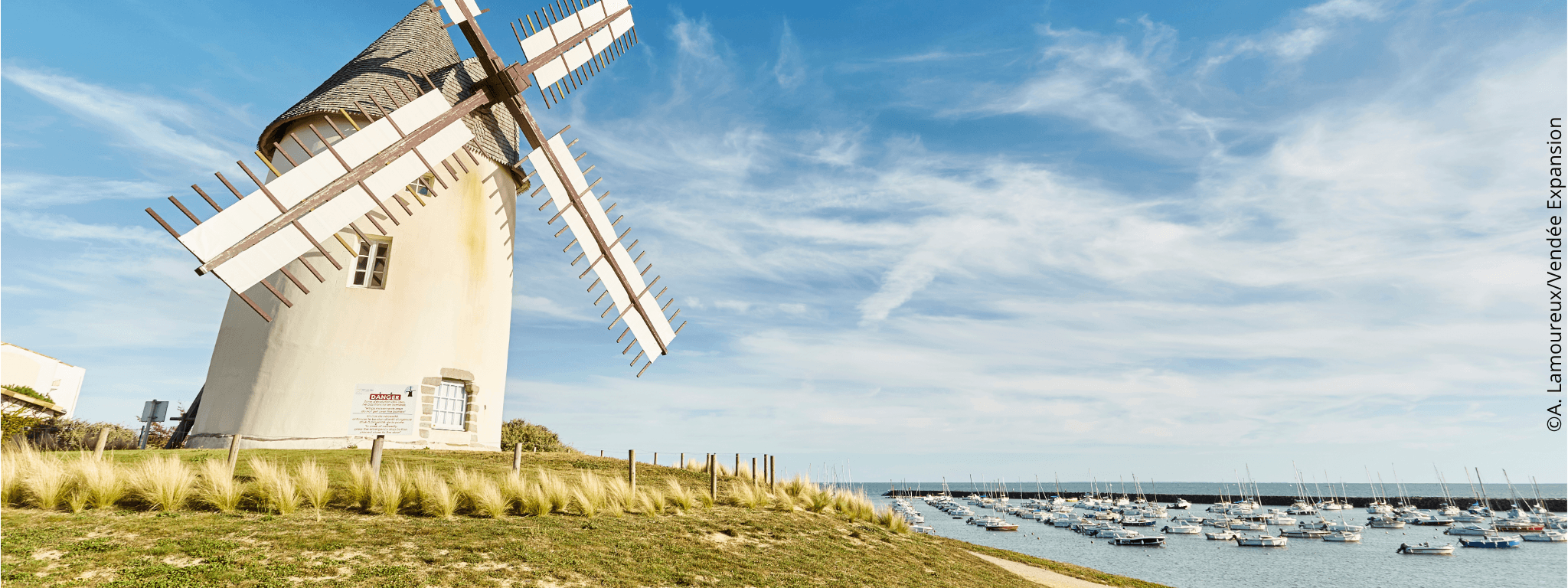 Moulin de Jard sur Mer sous un beau ciel bleu à côté du port avec des bateaux amarrés