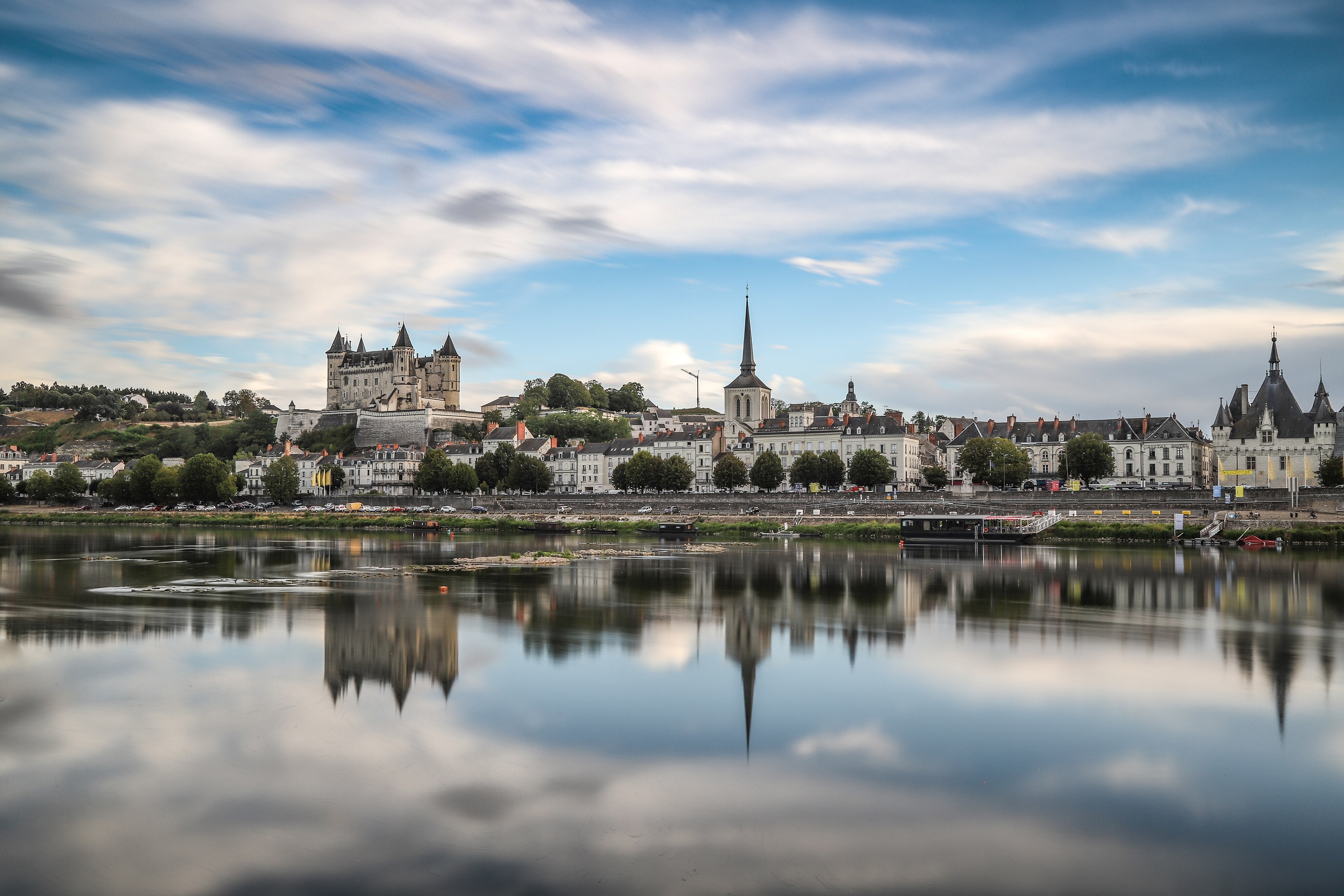 Vue depuis la Loire sur la ville de Saumur avec ses habitations, son château et le clocher d'une église