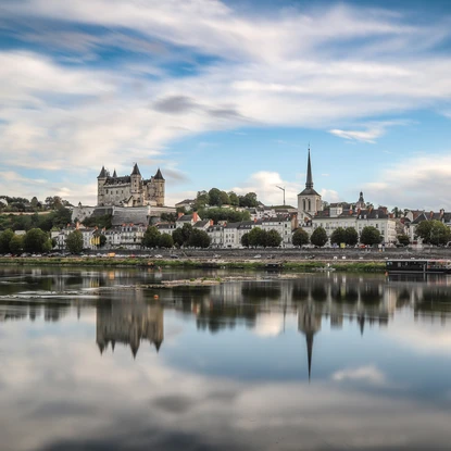 Vue depuis la Loire sur la ville de Saumur avec ses habitations, son château et le clocher d'une église
