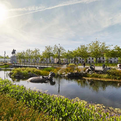 Vue sur les bassins entourés de verdure et les animaux mécaniques de la place Napoléon