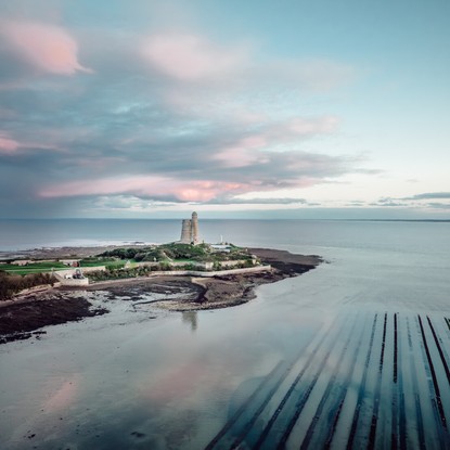 Tour Vauban de l'Ile Tatihou, parc à huitres, vue du ciel couleurs bleu et rose avec quelques nuages, ambiance féérique © Xavier Lachenaud - Attitude Manche