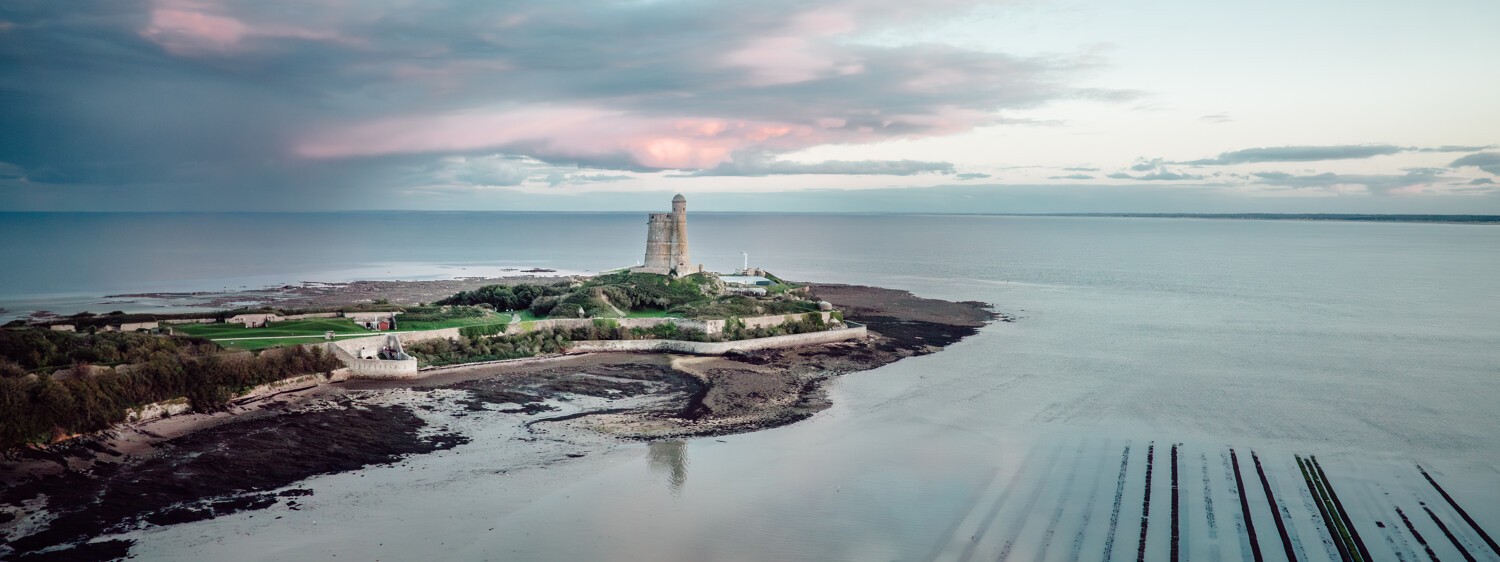 Vauban tower on the Ile Tatihou, oyster park, view of the blue and pink sky with a few clouds, magical atmosphere © Xavier Lachenaud - Attitude Manche