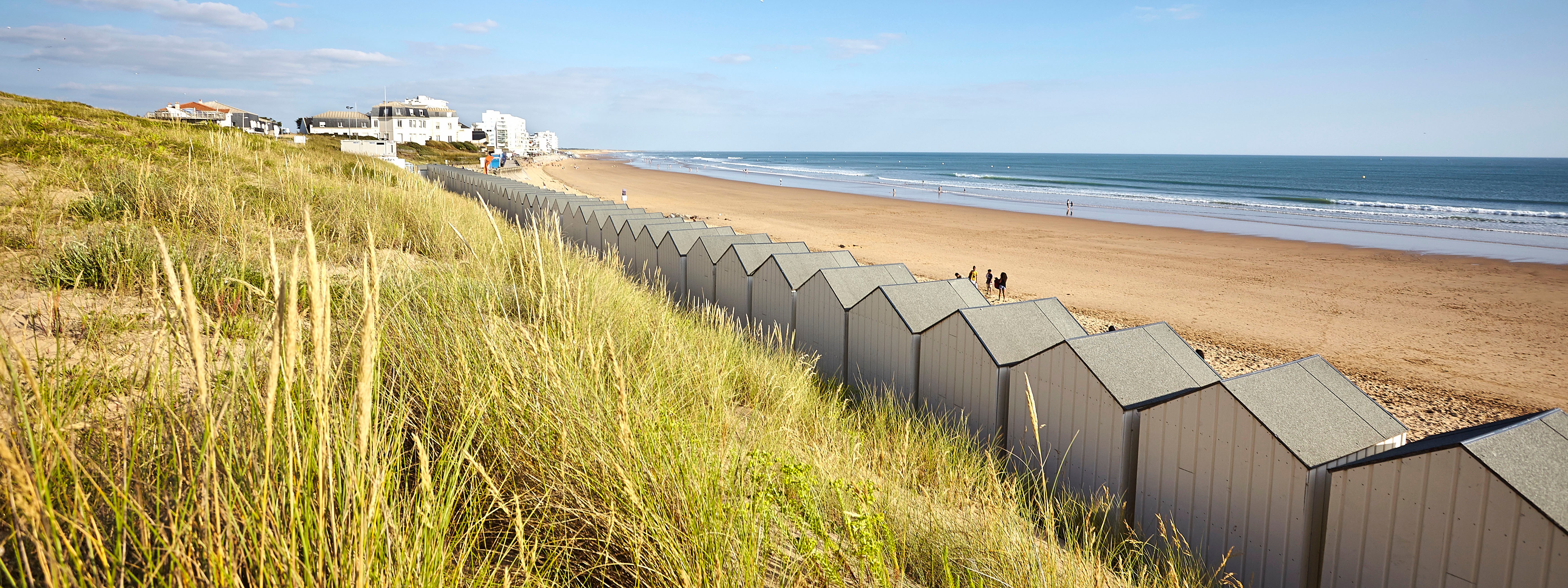 From the wild dunes, view of the large beach of Saint Gilles Croix de vie with the beach huts under a beautiful blue sky - A. Lamoureux/Vendée Expansion - rights reserved - www.vendee-tourisme.com / any reproduction or publication prohibited