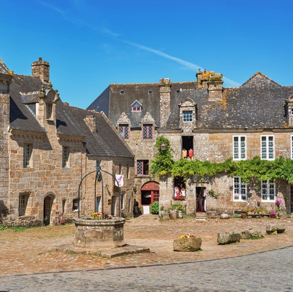 Maison en pierre avec puit, ciel bleu à Locronan, cité de caractère