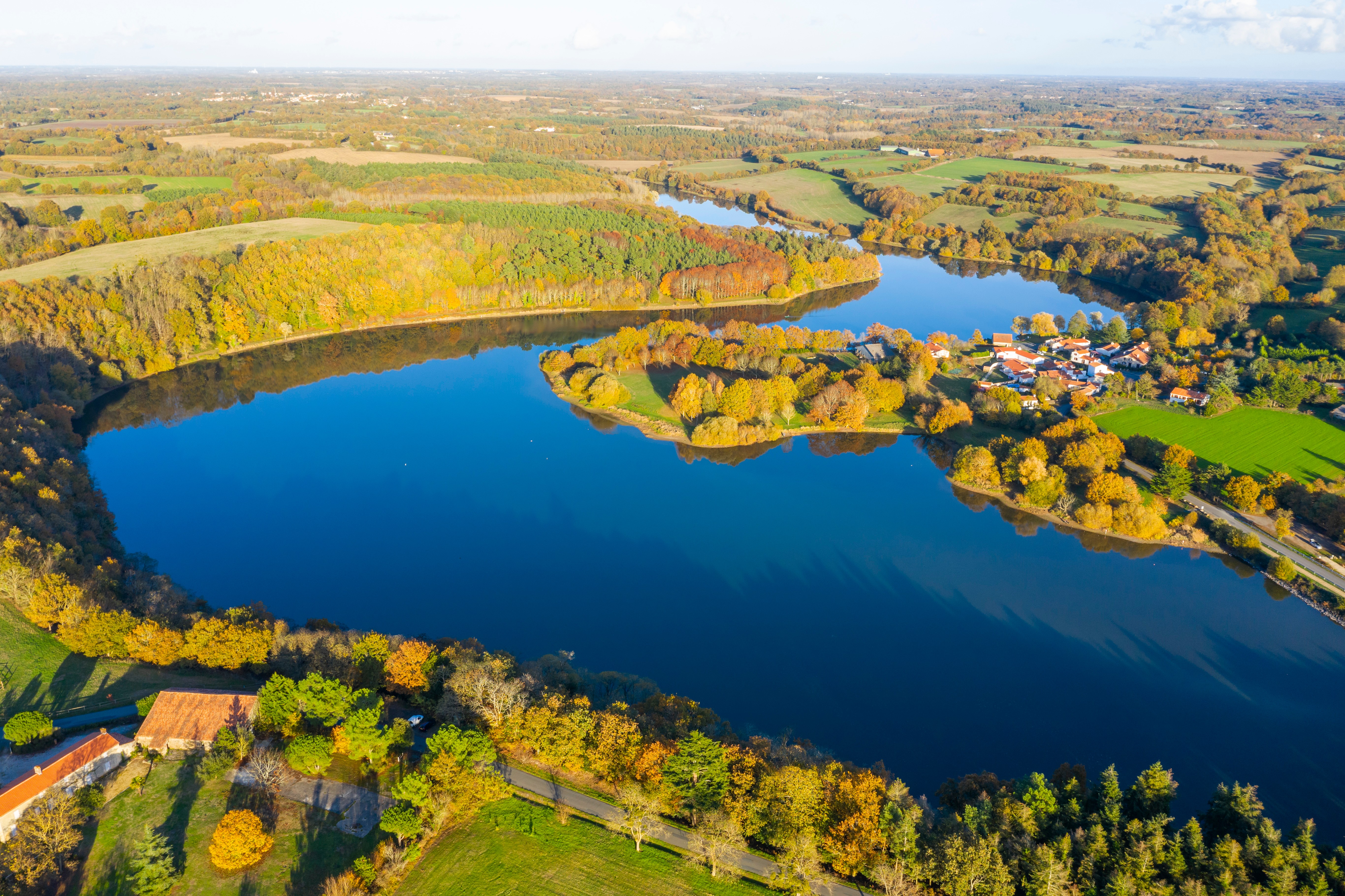 Vue aérienne sur le lac du Jaunay avec quelques habitations et une campagne verdoyante