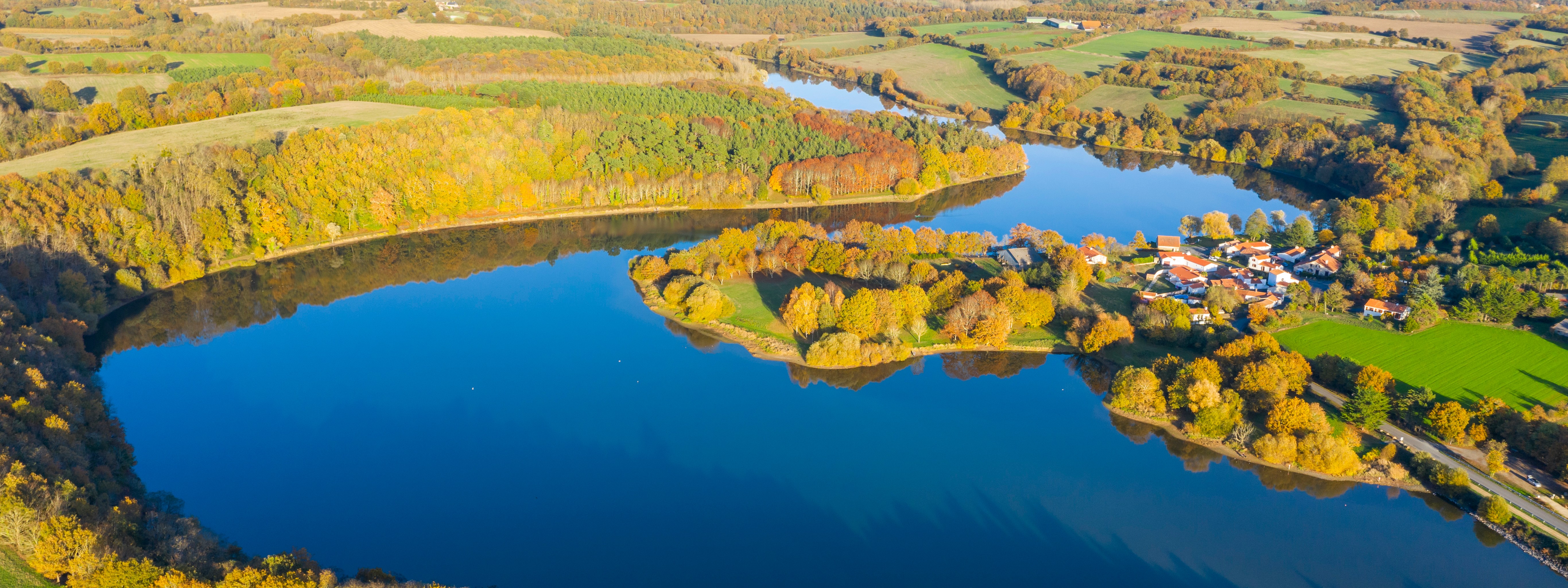Vue aérienne sur le lac du Jaunay avec quelques habitations et une campagne verdoyante