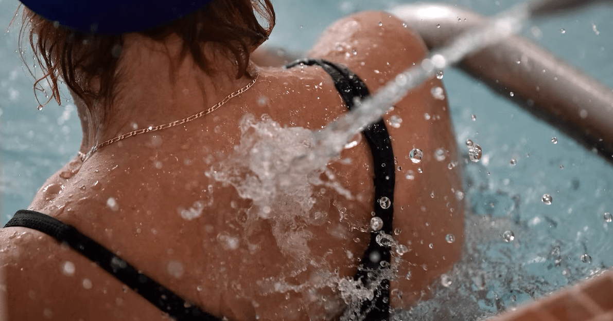 Personne profitant d'un massage d'eau sous pression sur les épaules dans un spa.