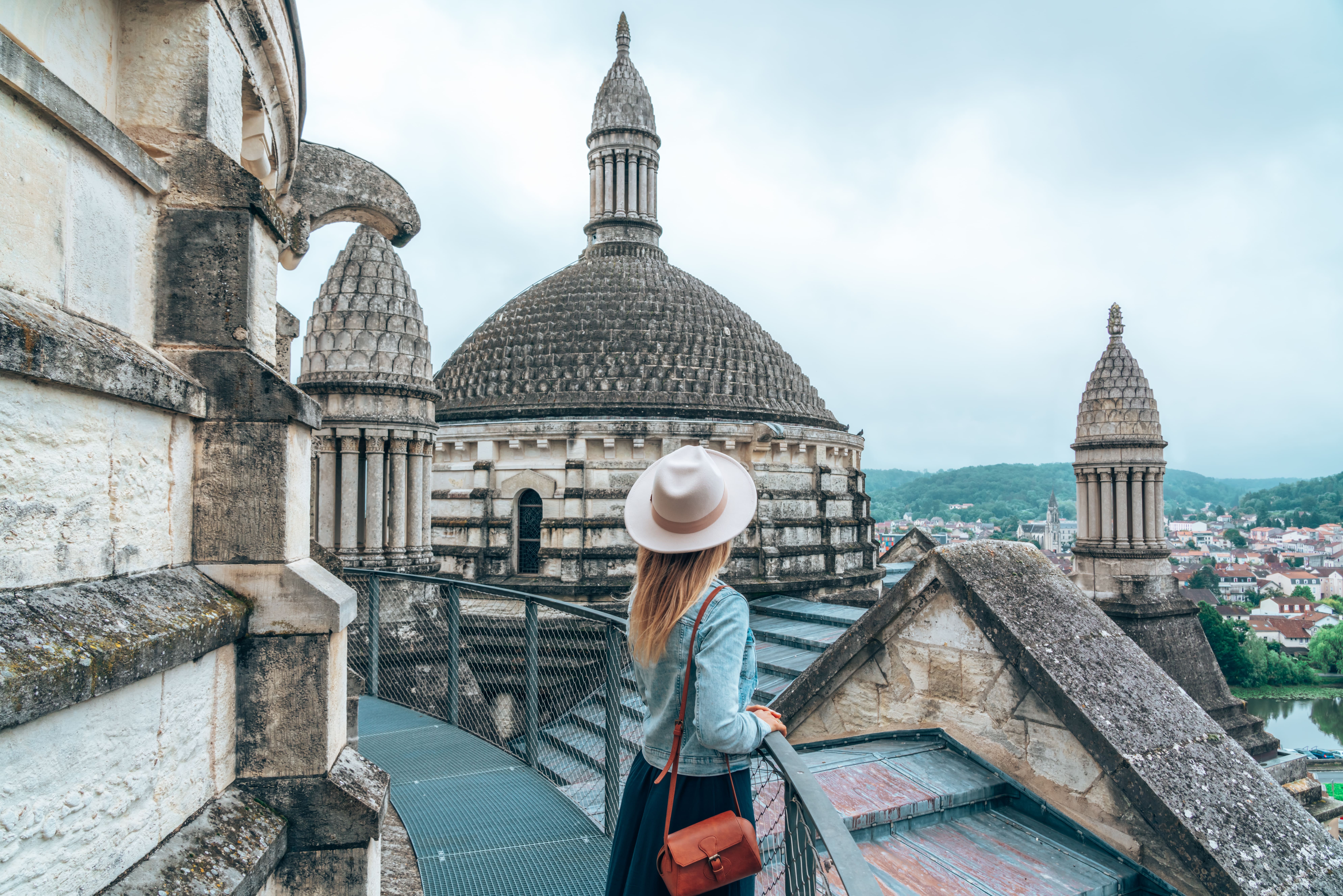 Femme portant un chapeau contemple la ville.