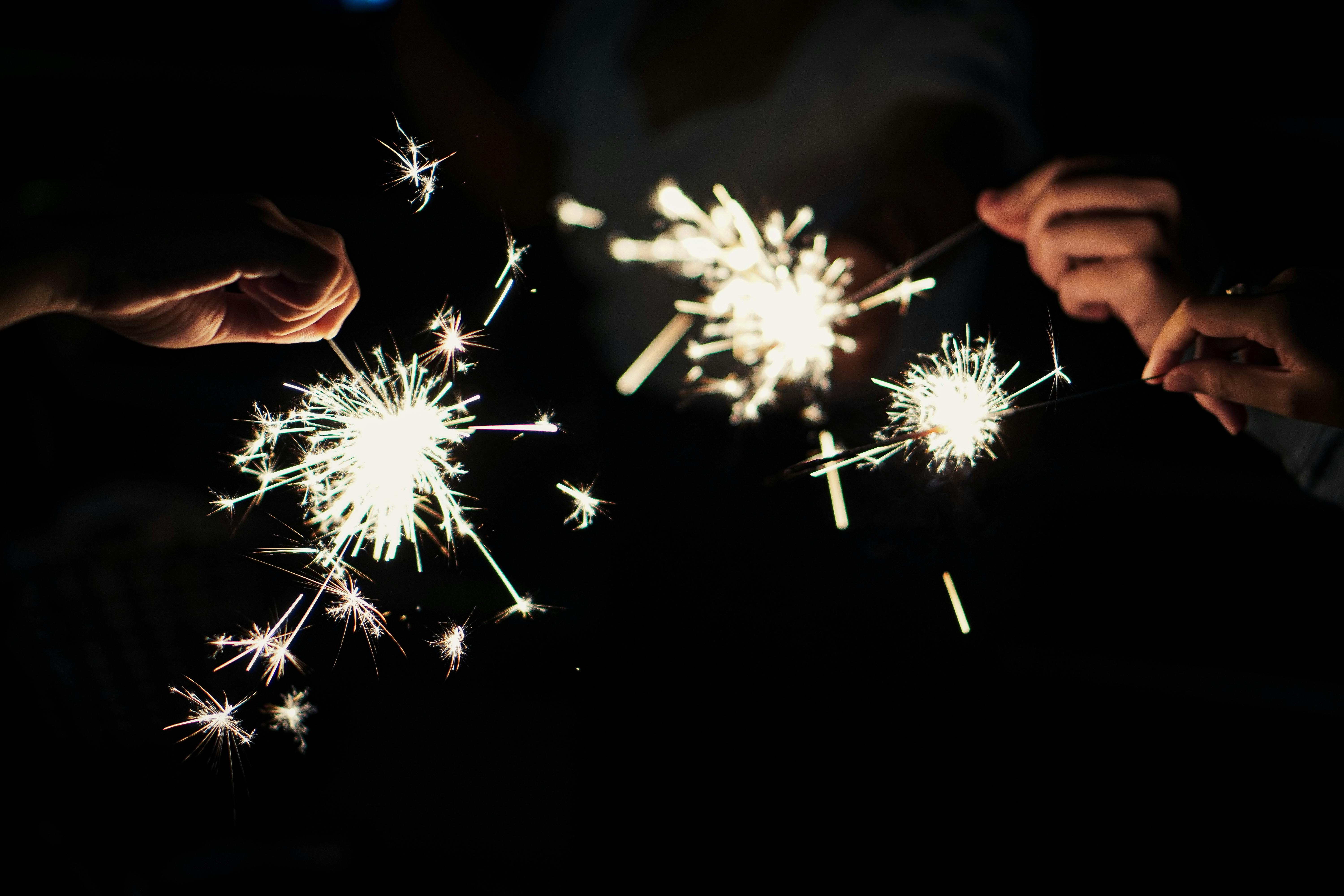 Étincelles lumineuses dans la nuit, créant une ambiance festive et magique.