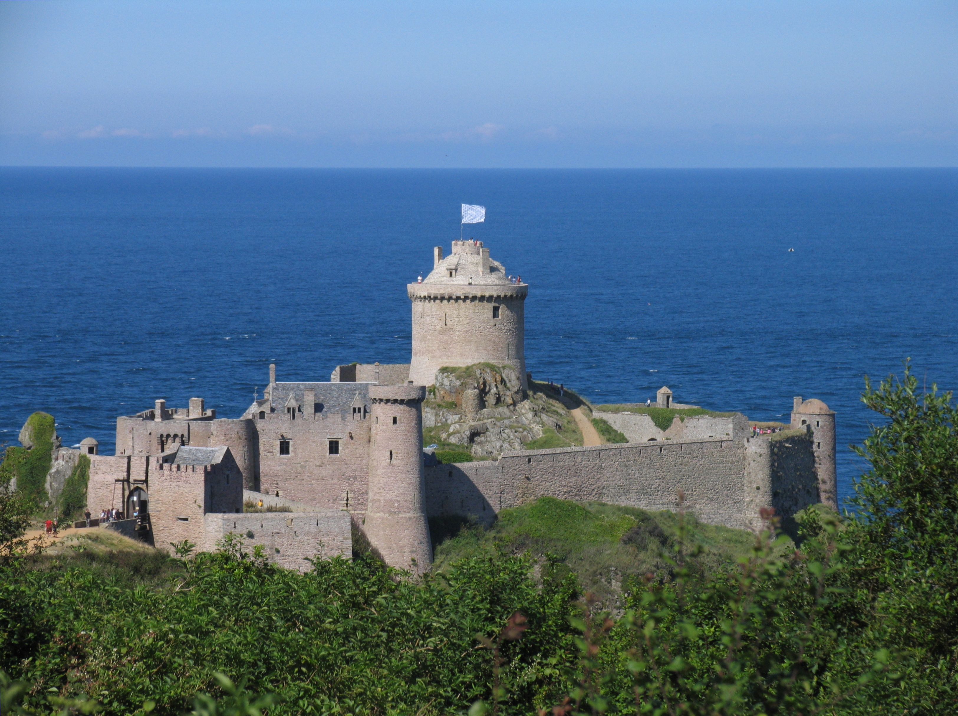 Fort Lalatte sur la commune de Plévenon avec ciel et mer bleu, drapeau flottant au sommet de la tour