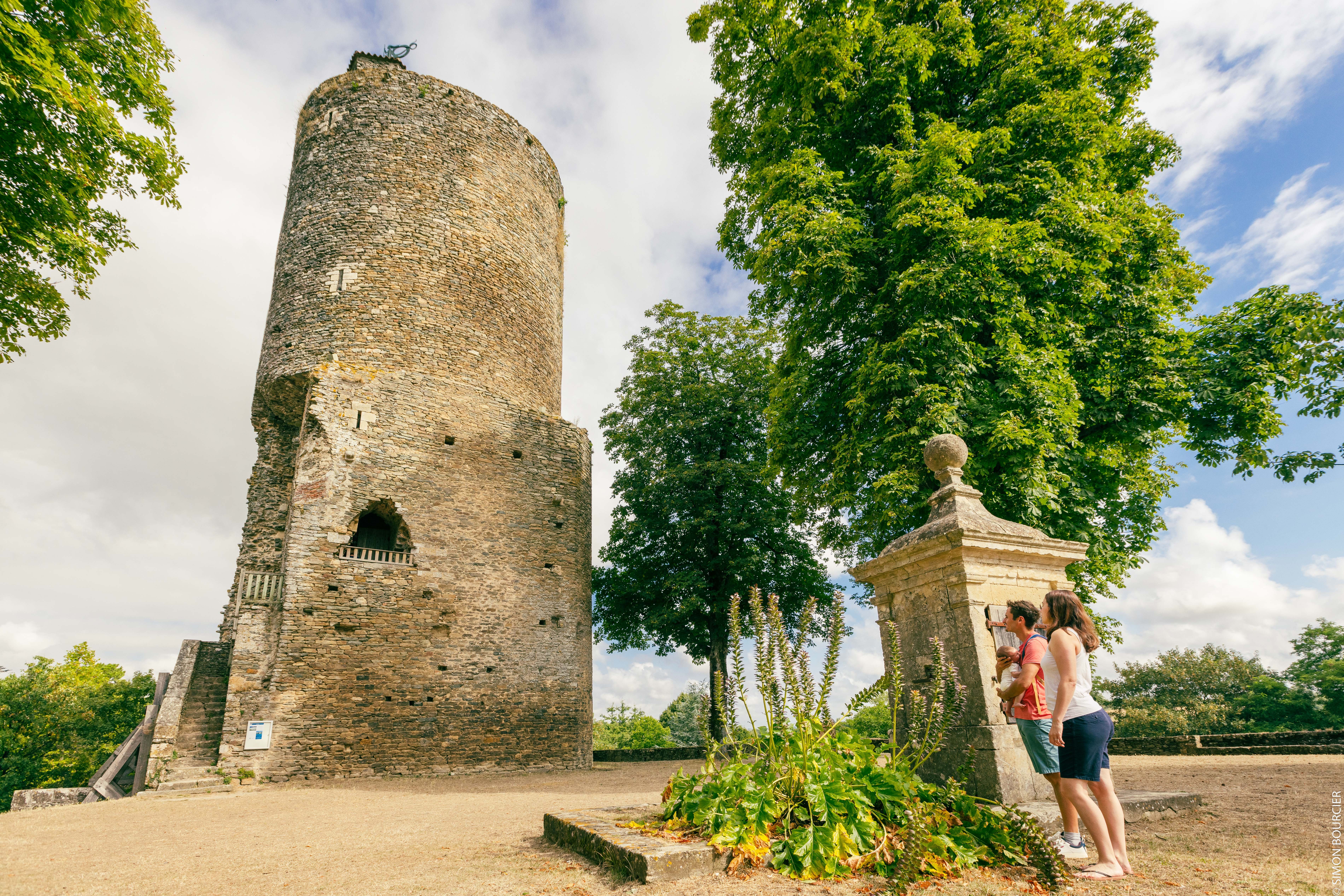 Personnes au pied de la tour Mélusine à Vouvant