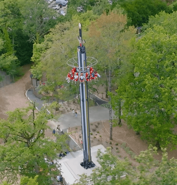Tour de chute libre Excalibur vue du dessus avec des visiteurs assis au sommet de la tour avant la descente