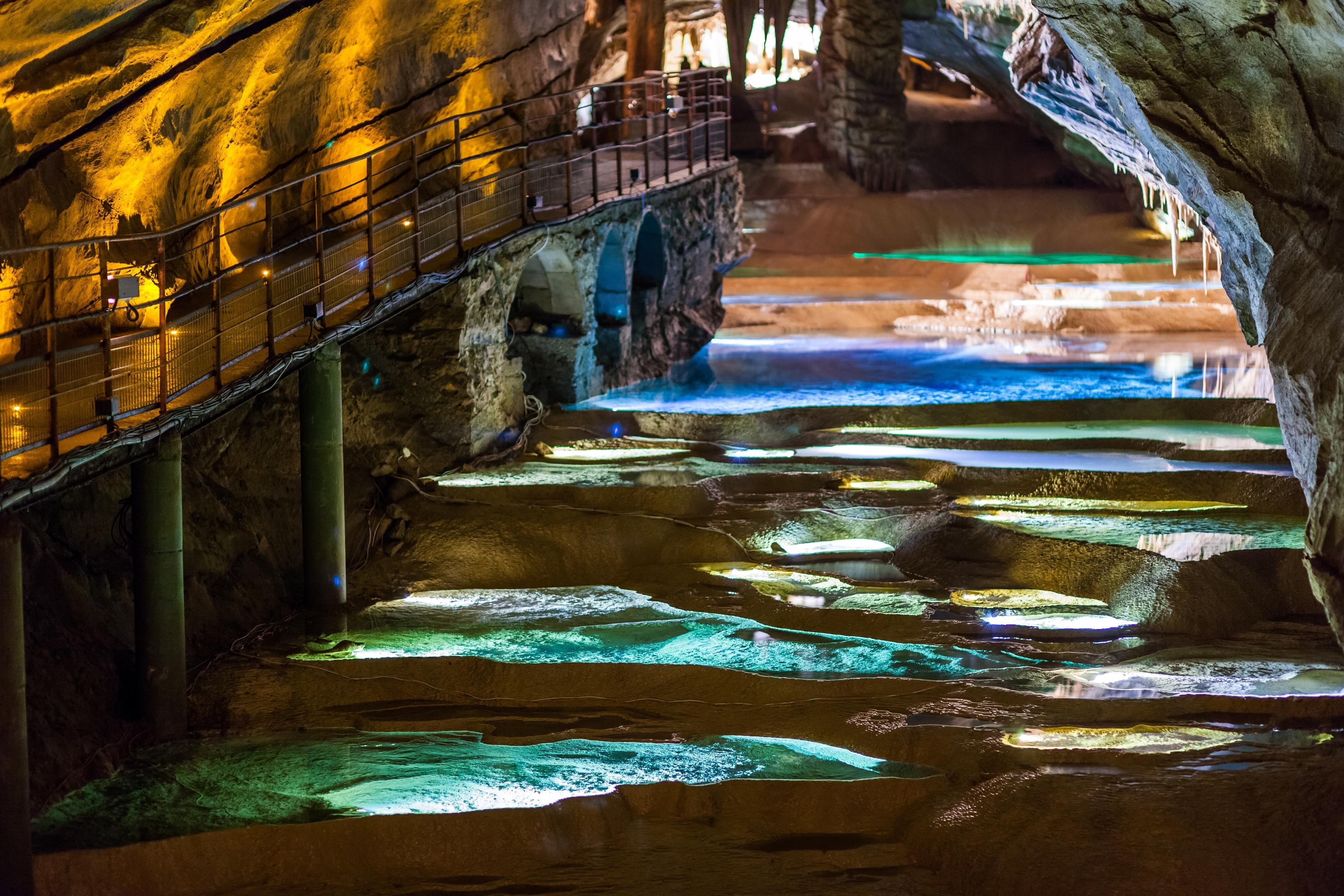 Les gours éclairés de lumières colorées de la grotte de la Cocalière à Courry dans le Gard