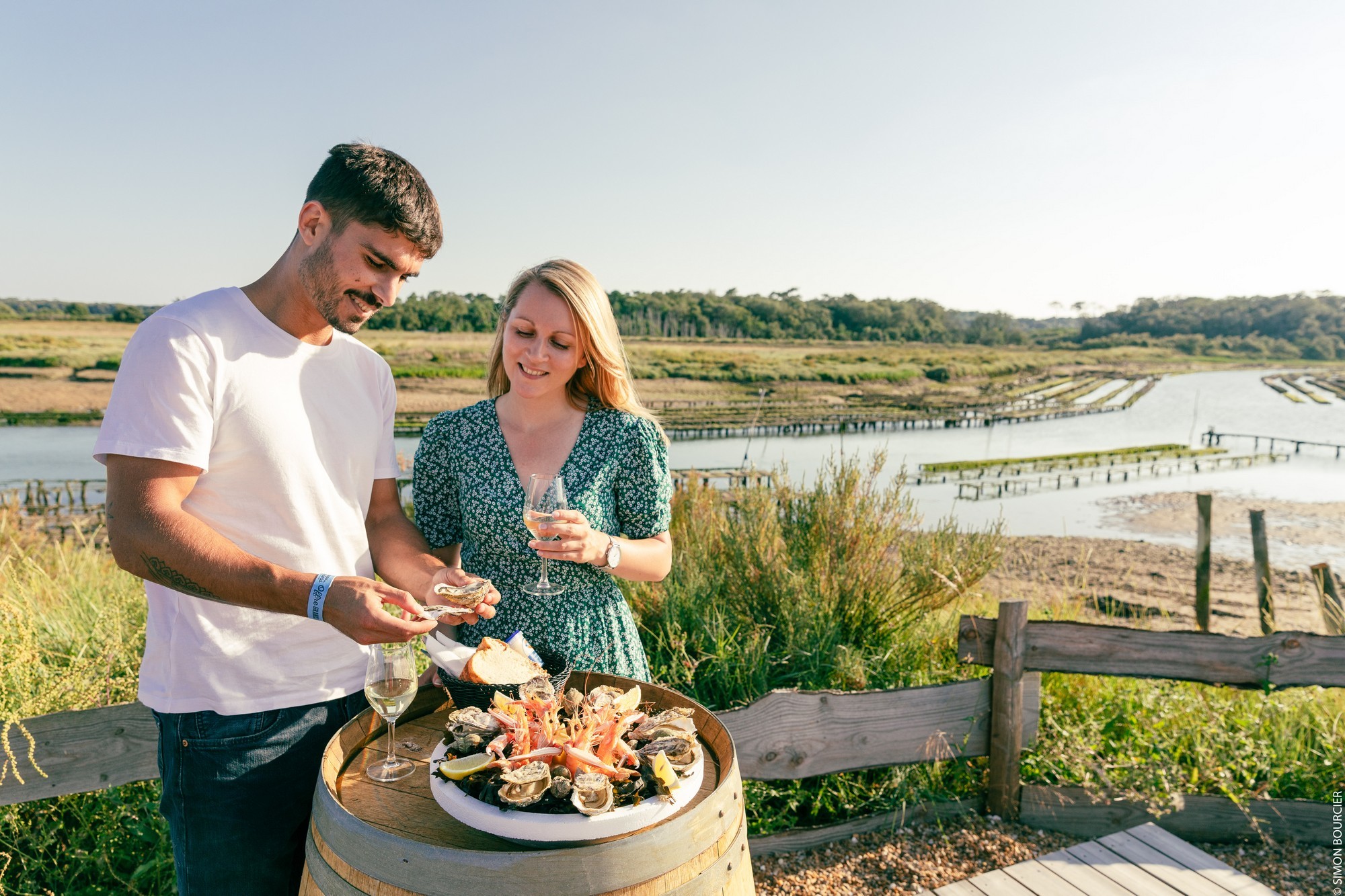 Un couple dégustant un plateau de fruits de mer avec des huîtres au port ostréicole de la Guittière