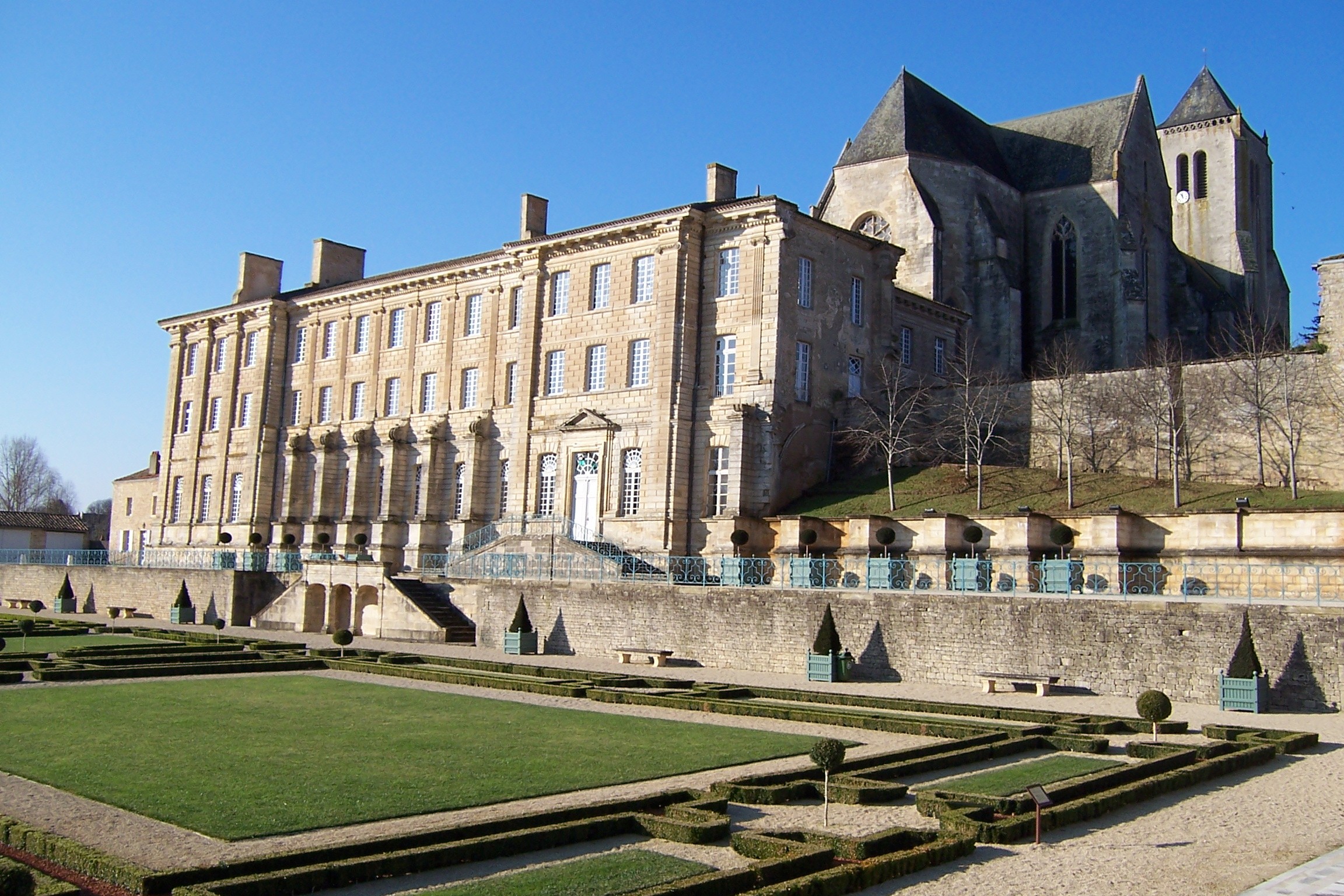 Architecture remarquable de l’Abbaye royale de Celles sur Belle avec son jardin à la française verdoyant avec des formes symétriques. 