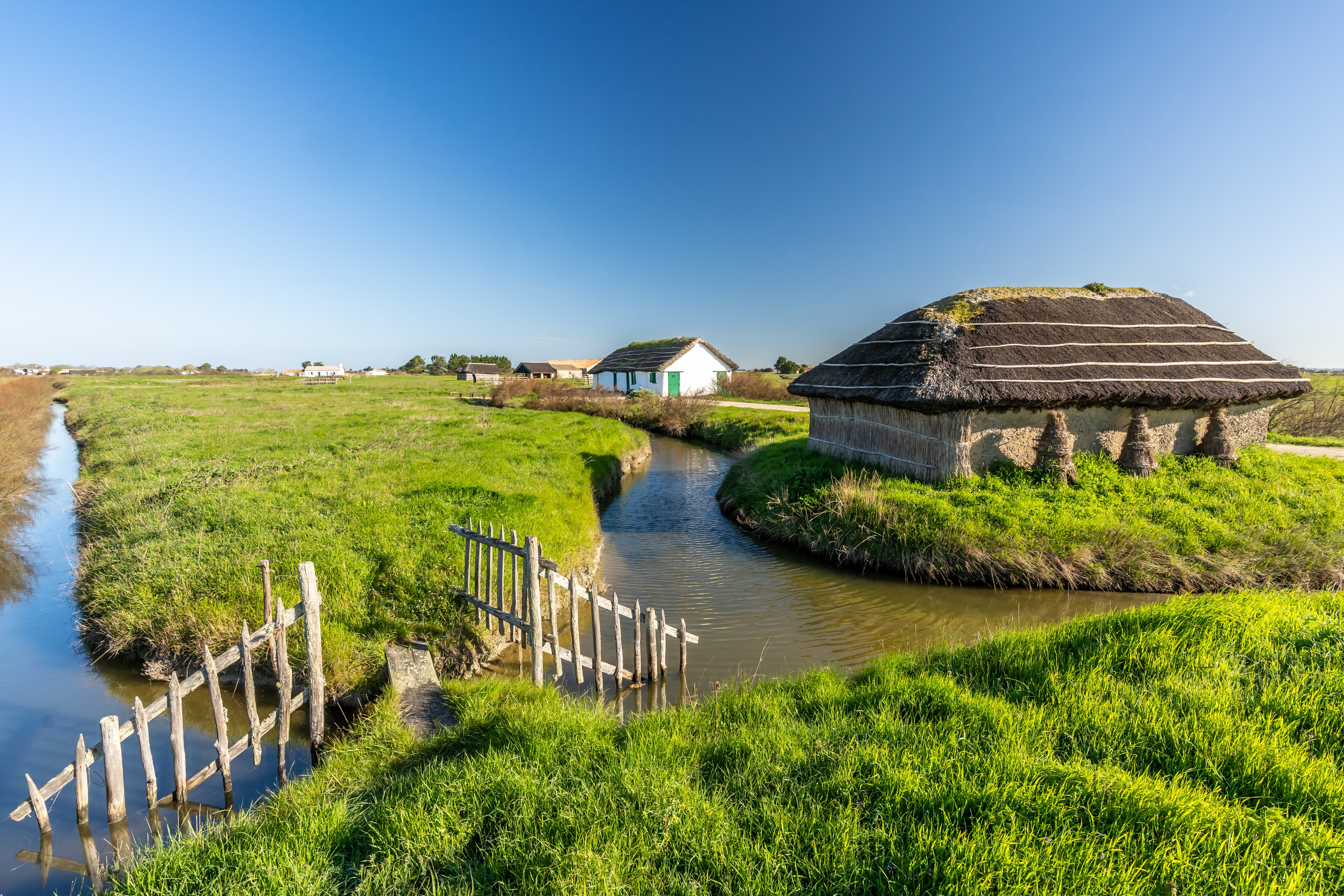 Plusieurs maisons traditionnelles avec toiture en roseaux au bord des marais Breton