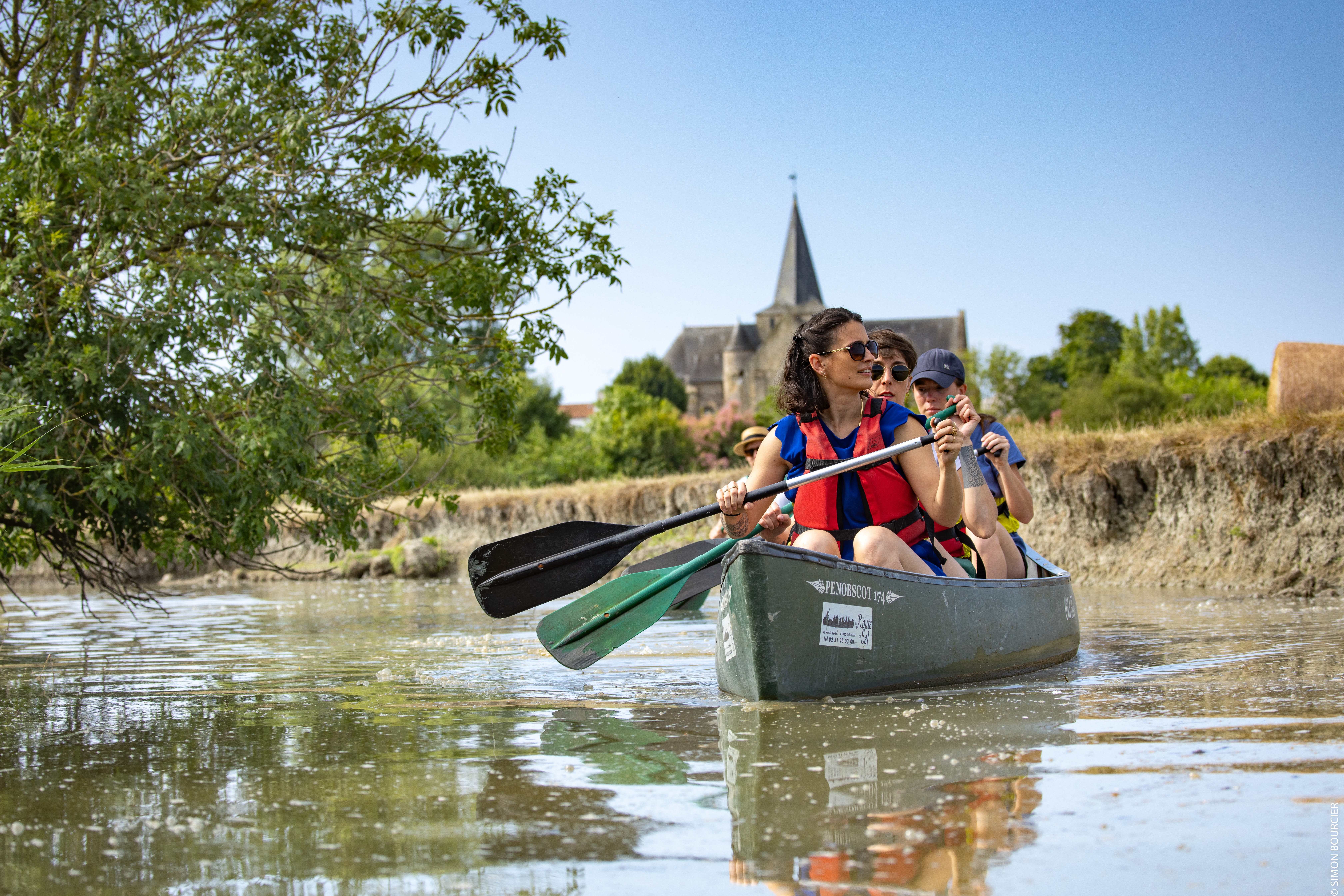 Personnes se baladant en barque sur le marais à travers les champs