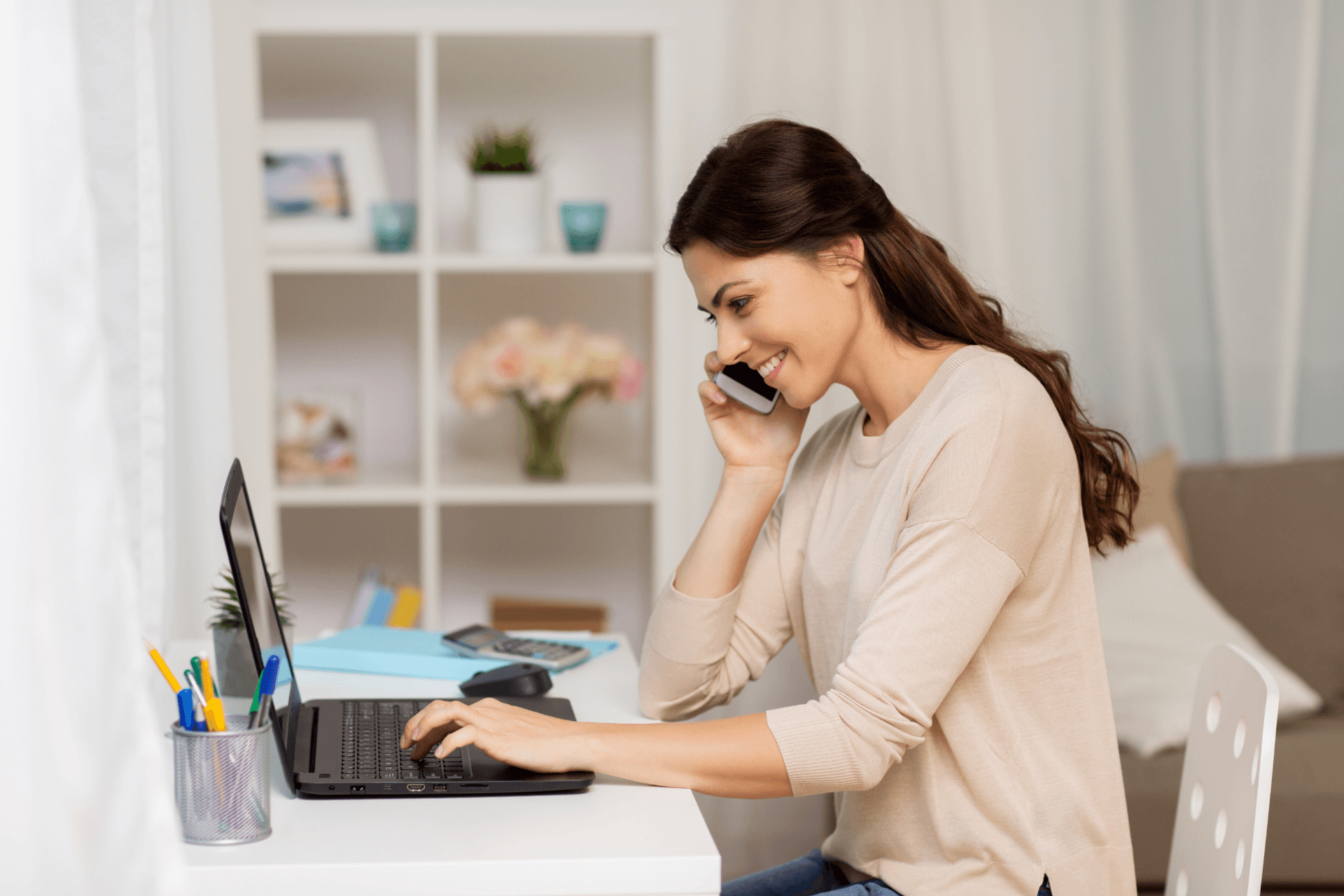 Femme au téléphone avec un propriétaire Clévacances pour discuter de l'hébergement et le réserver auprès du propriétaire