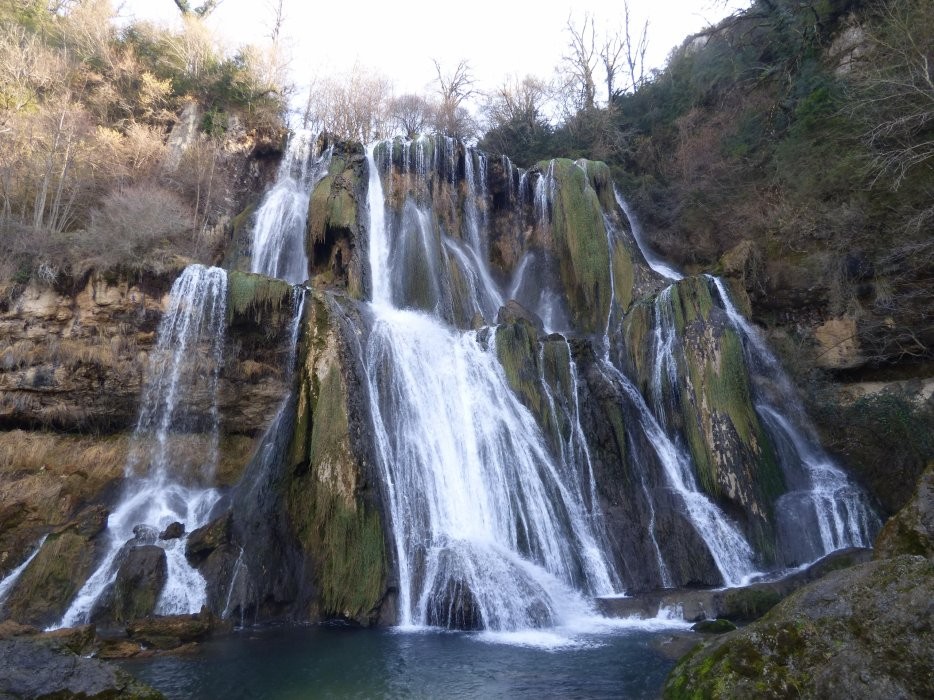 Grande chute d’eau de la cascade de Glandieu entourée d’une nature verdoyante. 