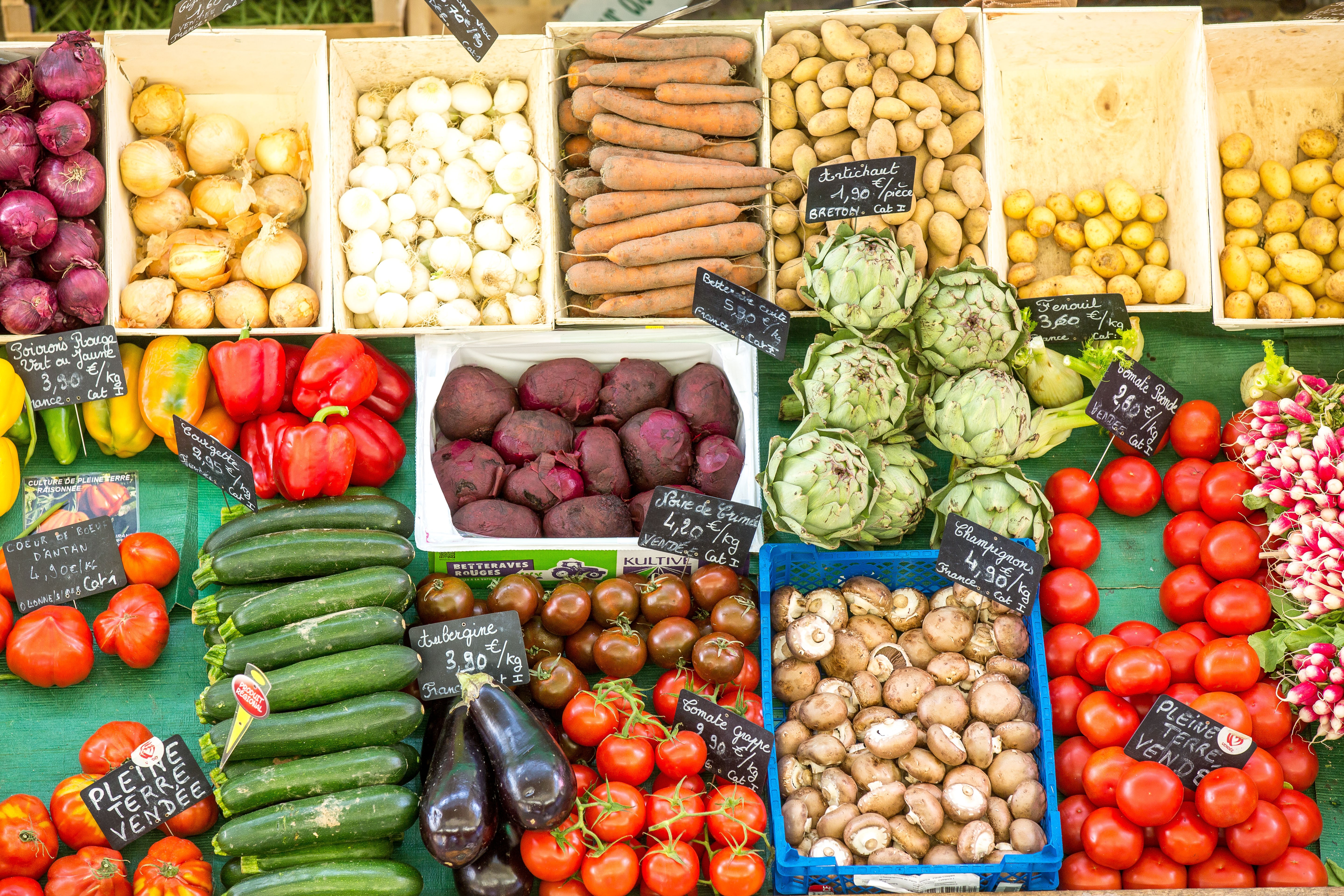 Étale du marché avec des légumes frais comme la courgette, les tomates, les betteraves, champignons…