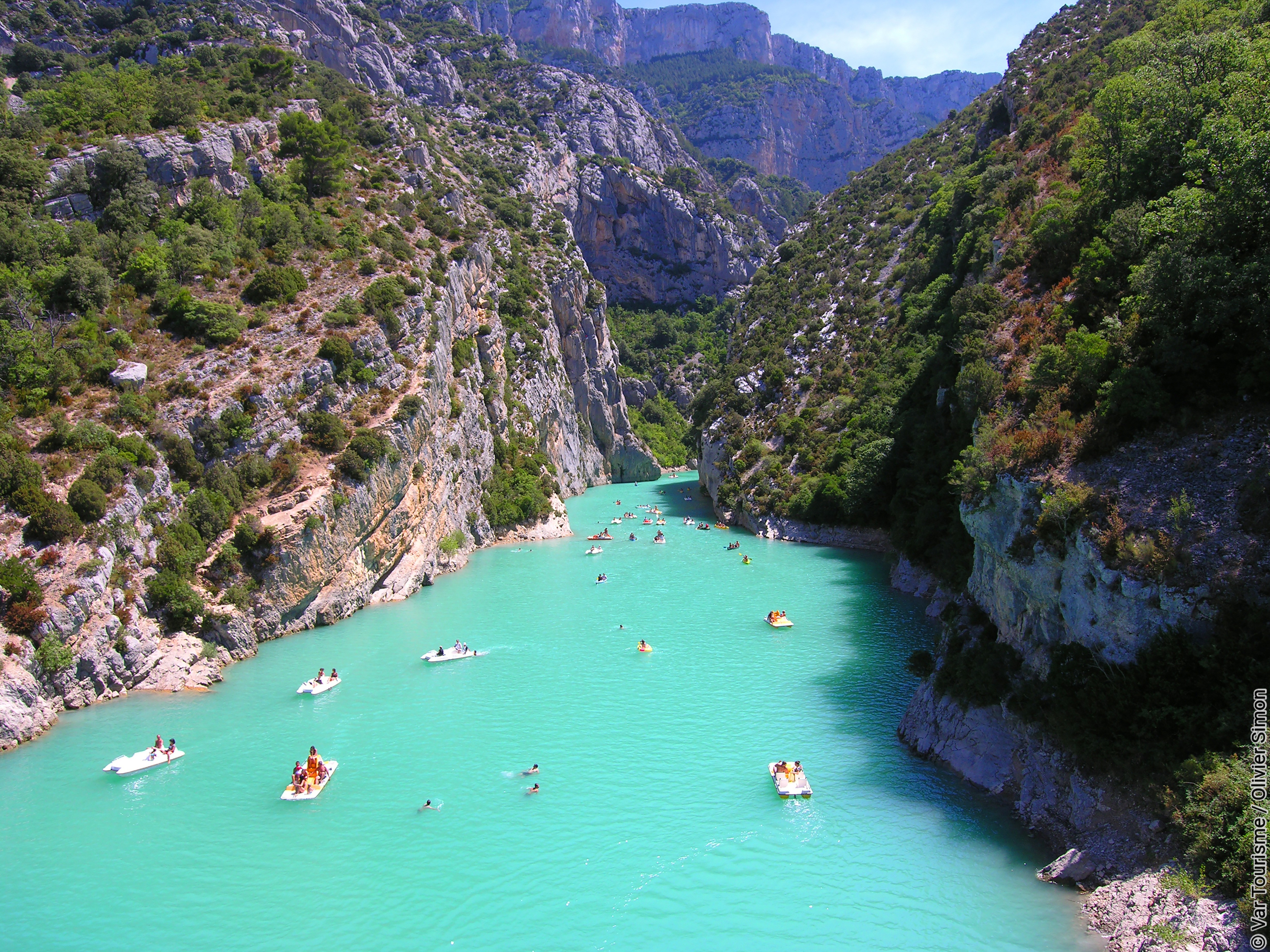 Depuis le célèbre Pont du Galetas, vue sur l’entrée des Gorges du Verdon avec ses nombreux bateaux de tourisme et canoë en saison estivale et les eaux cristallines du Verdon