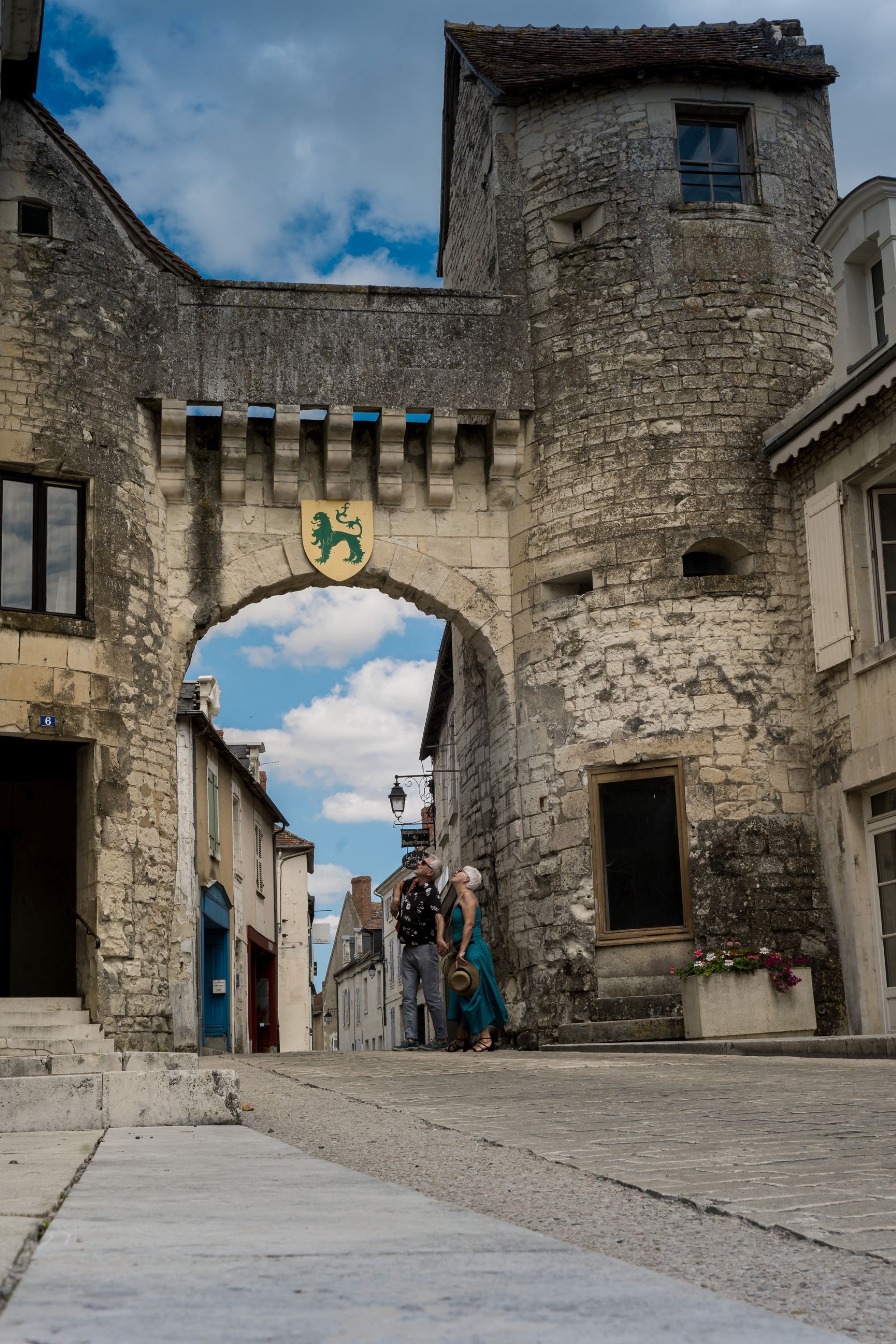 Porte d’entrée de la cité médiévale de la Roche Posay avec un couple situé en dessous et qui regarde en haut