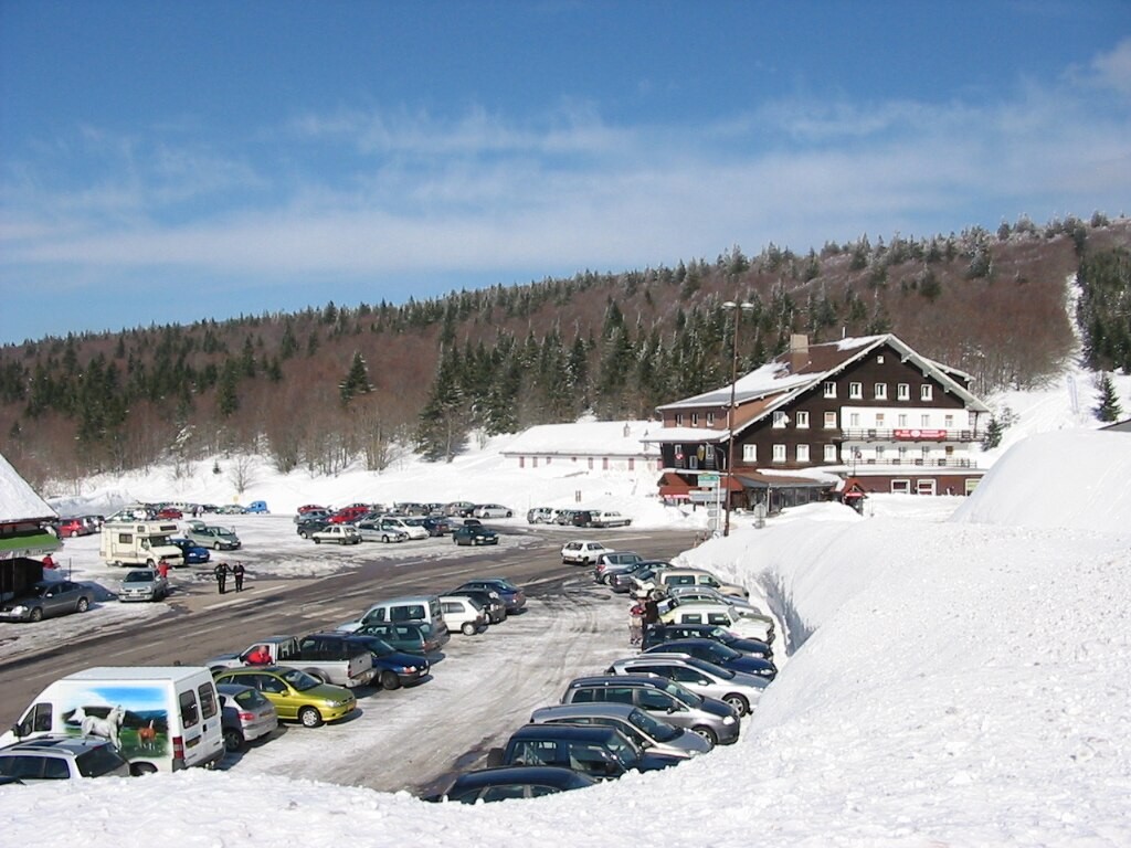 Parking du Col de la Schluch enneigé avec forêt en fond