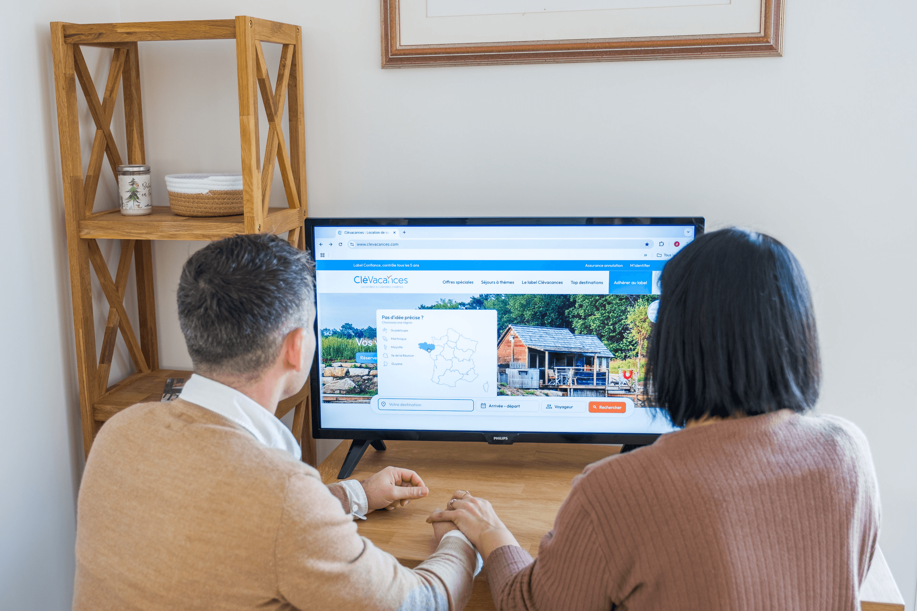 Couple entrain de naviguer sur le site internet www.clevacances.com afin de réserver leur hébergement de vacances