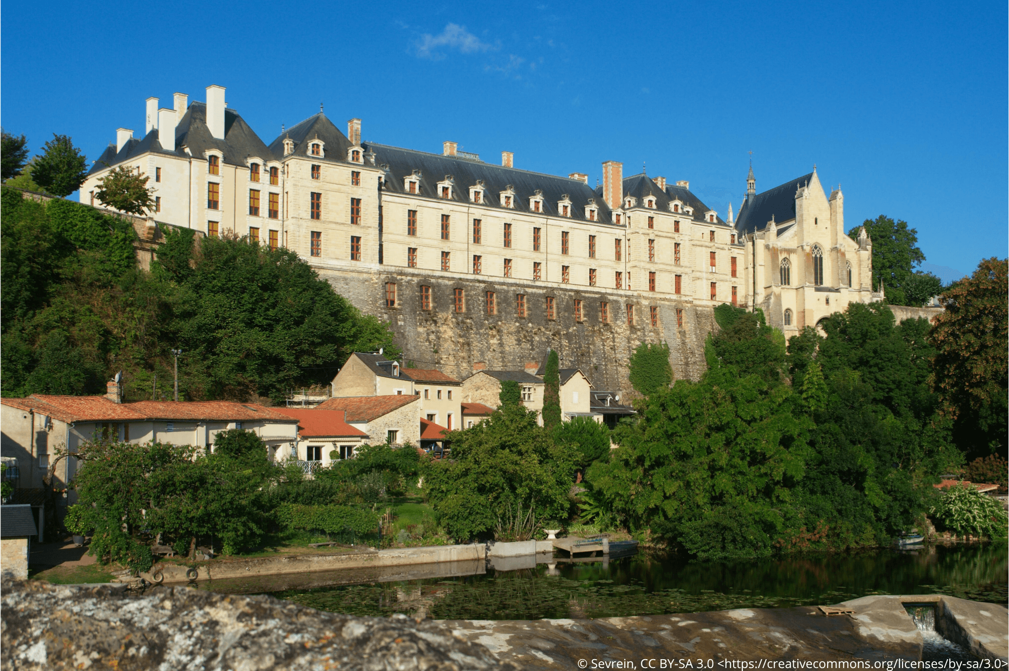 Vue sur la large façade du château des Ducs de la Trémoille depuis la rivière du Thouet