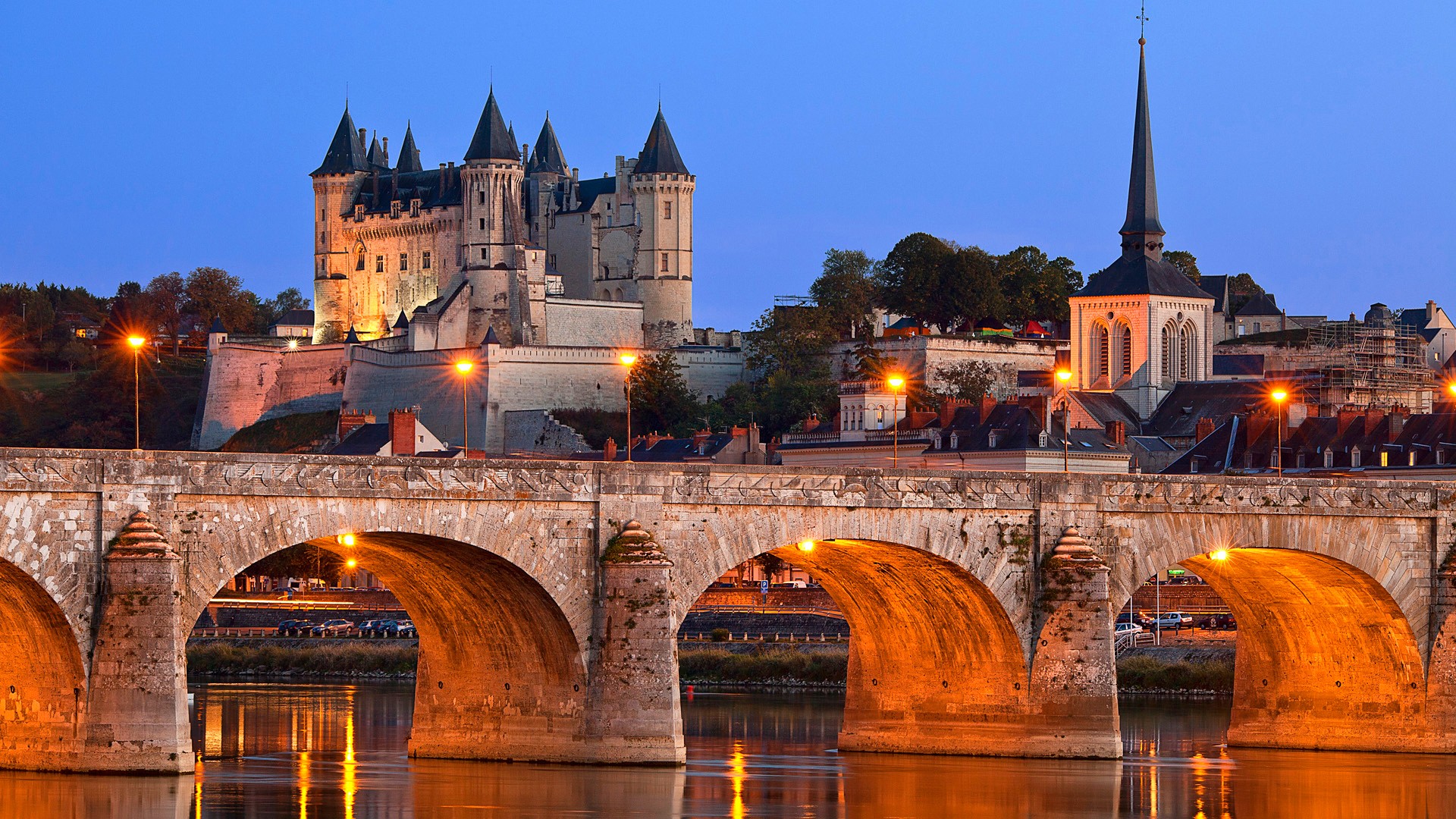 Château et Pont de Saumur, depuis la Loire avec un éclairage nocturne.