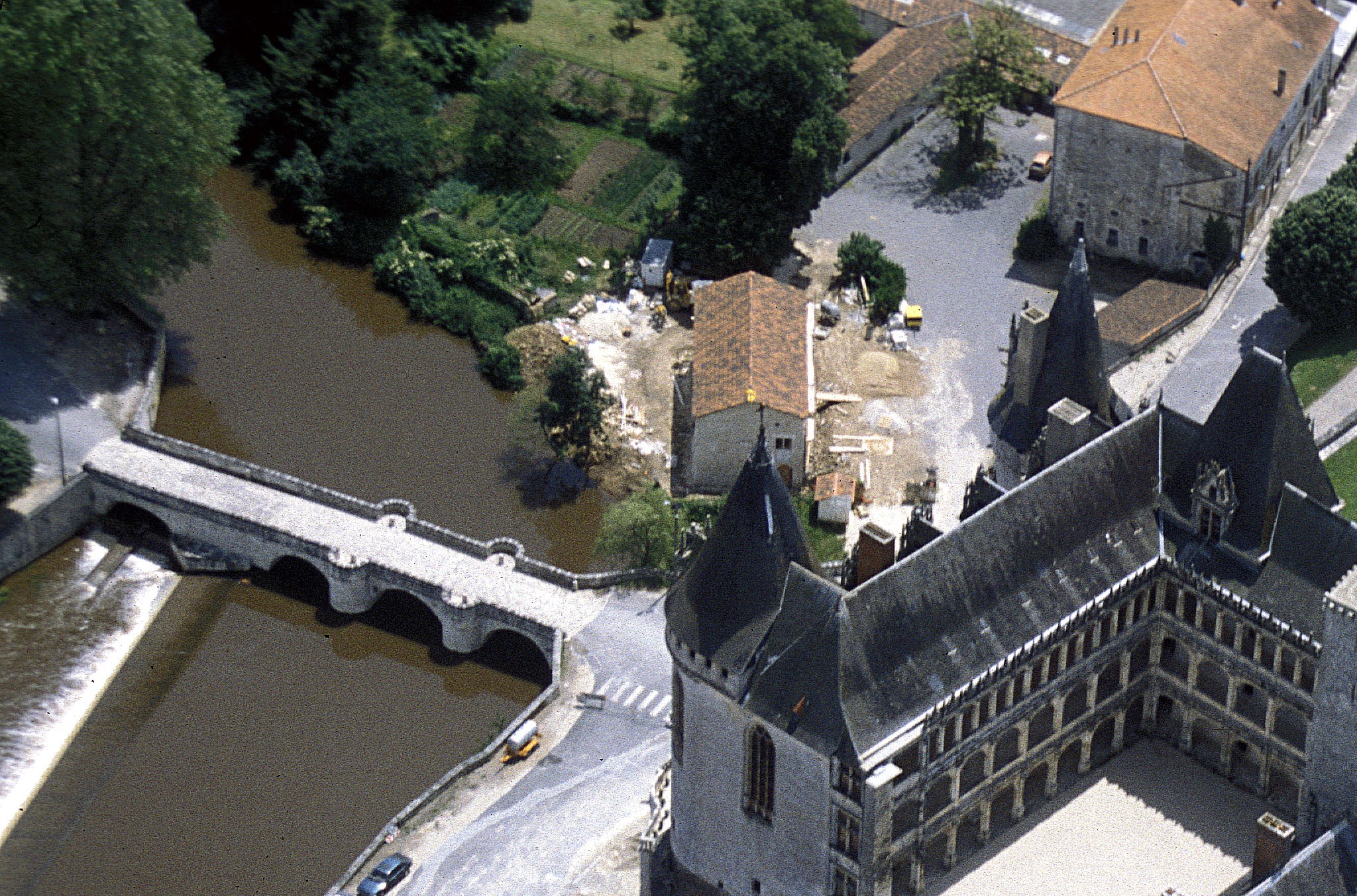 Vue aérienne sur le château de la Rochefoucauld, son vaste parc enherbé bien vert et sur le pont passant sur la rivière de la Tardoire.
