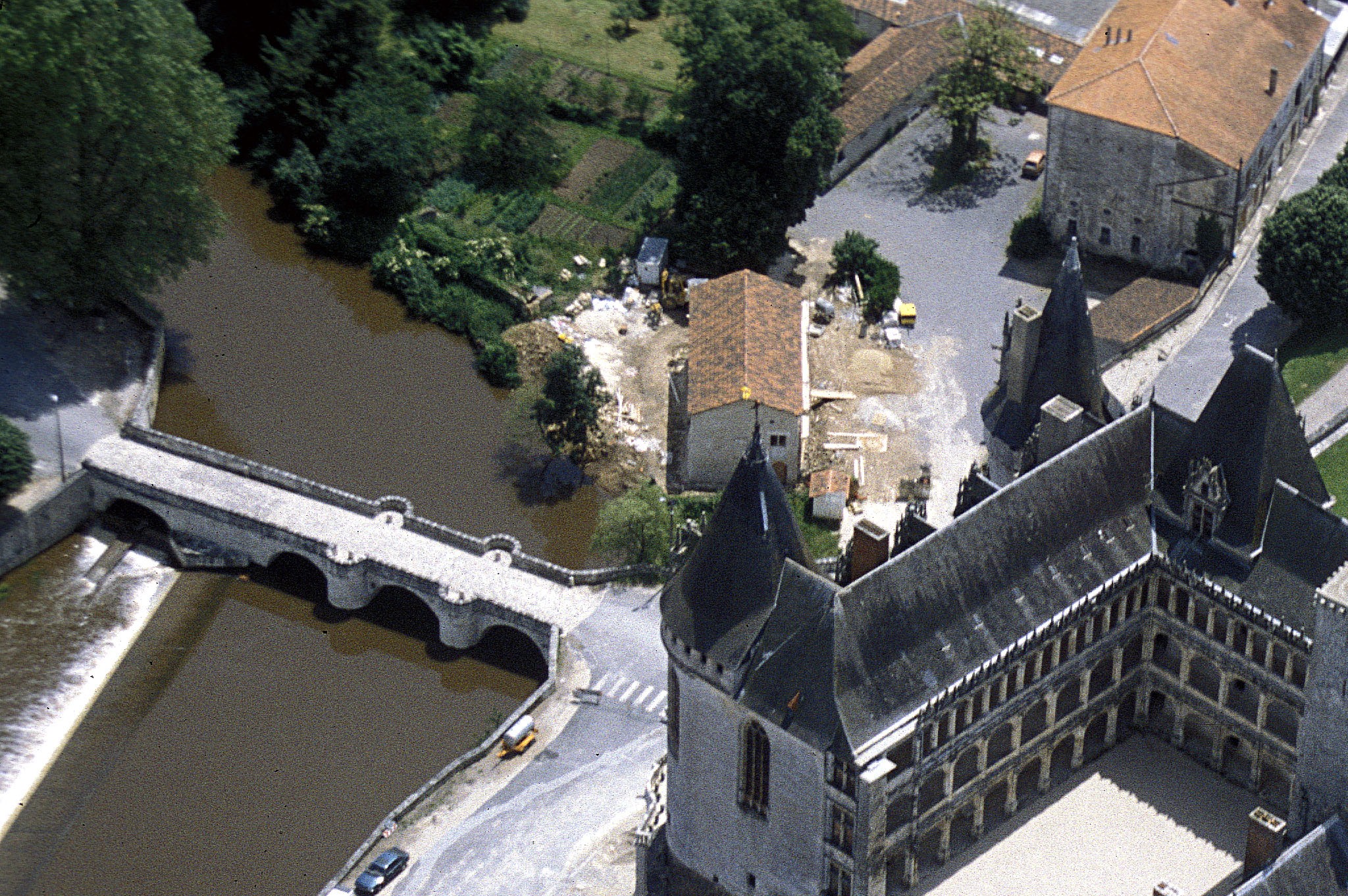 View of the broad façade of the Château des Ducs de la Trémoille from the Thouet river