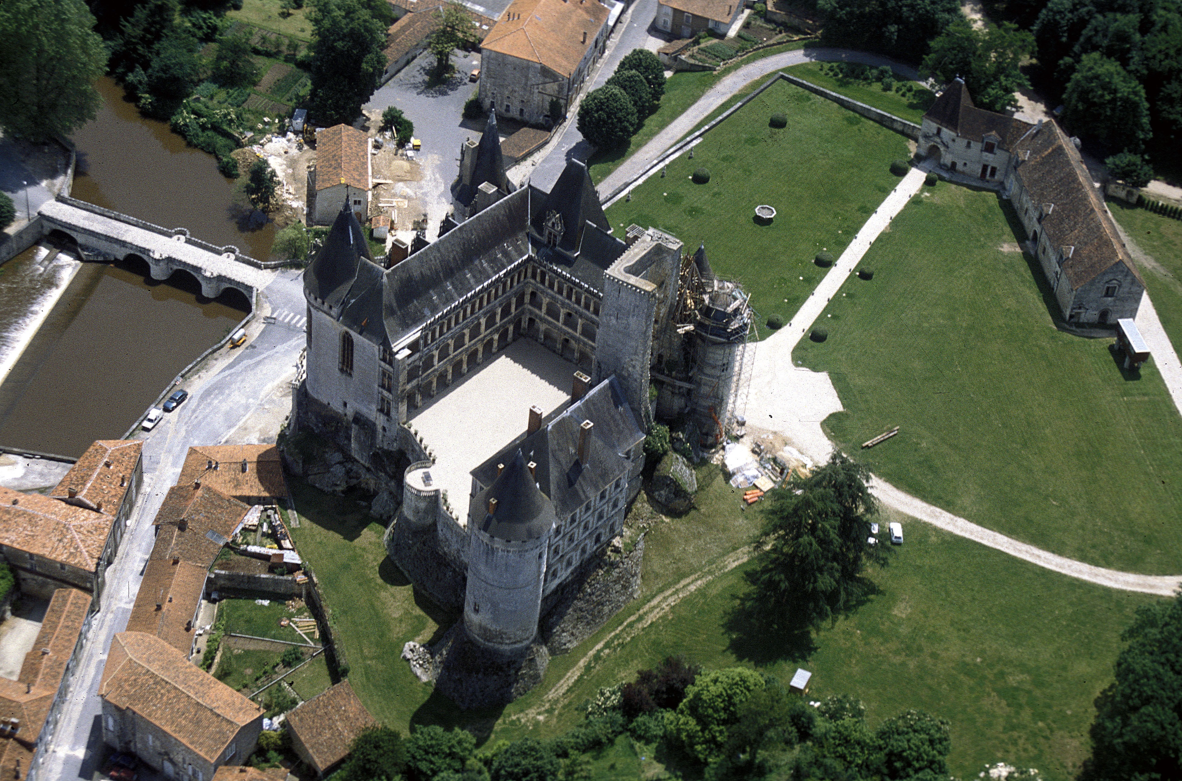Vue aérienne sur le château de la Rochefoucauld, son vaste parc enherbé bien vert et sur le pont passant sur la rivière de la Tardoire.