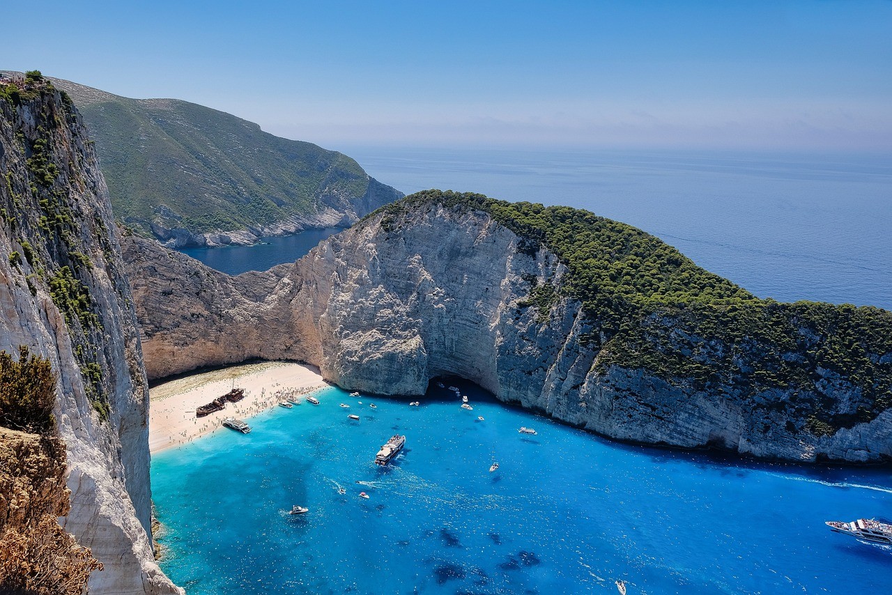 Vue aérienne spectaculaire d'une plage isolée entourée de falaises escarpées et d'une mer bleue cristalline