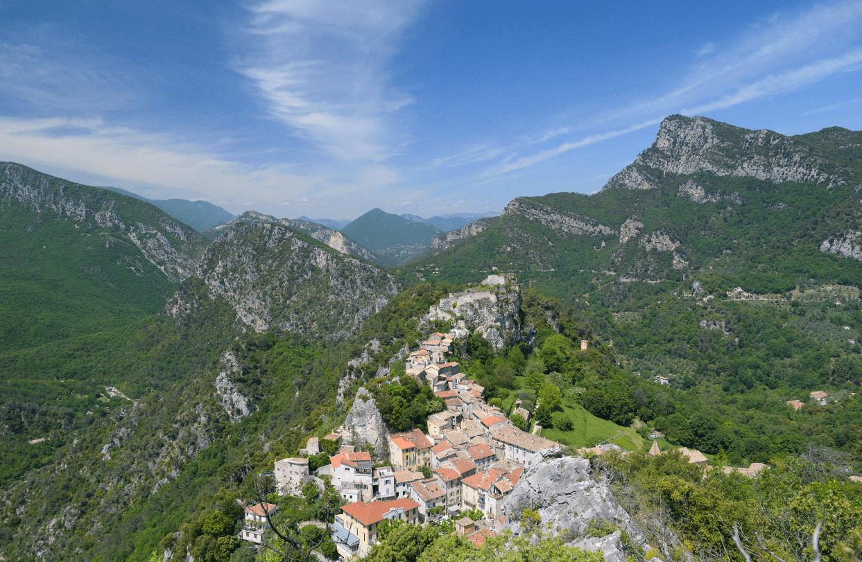 Vue aérienne du village perché de Gilette, de ses maisons typiques et de son château, au milieu des montagnes de l’arrière-pays niçois
